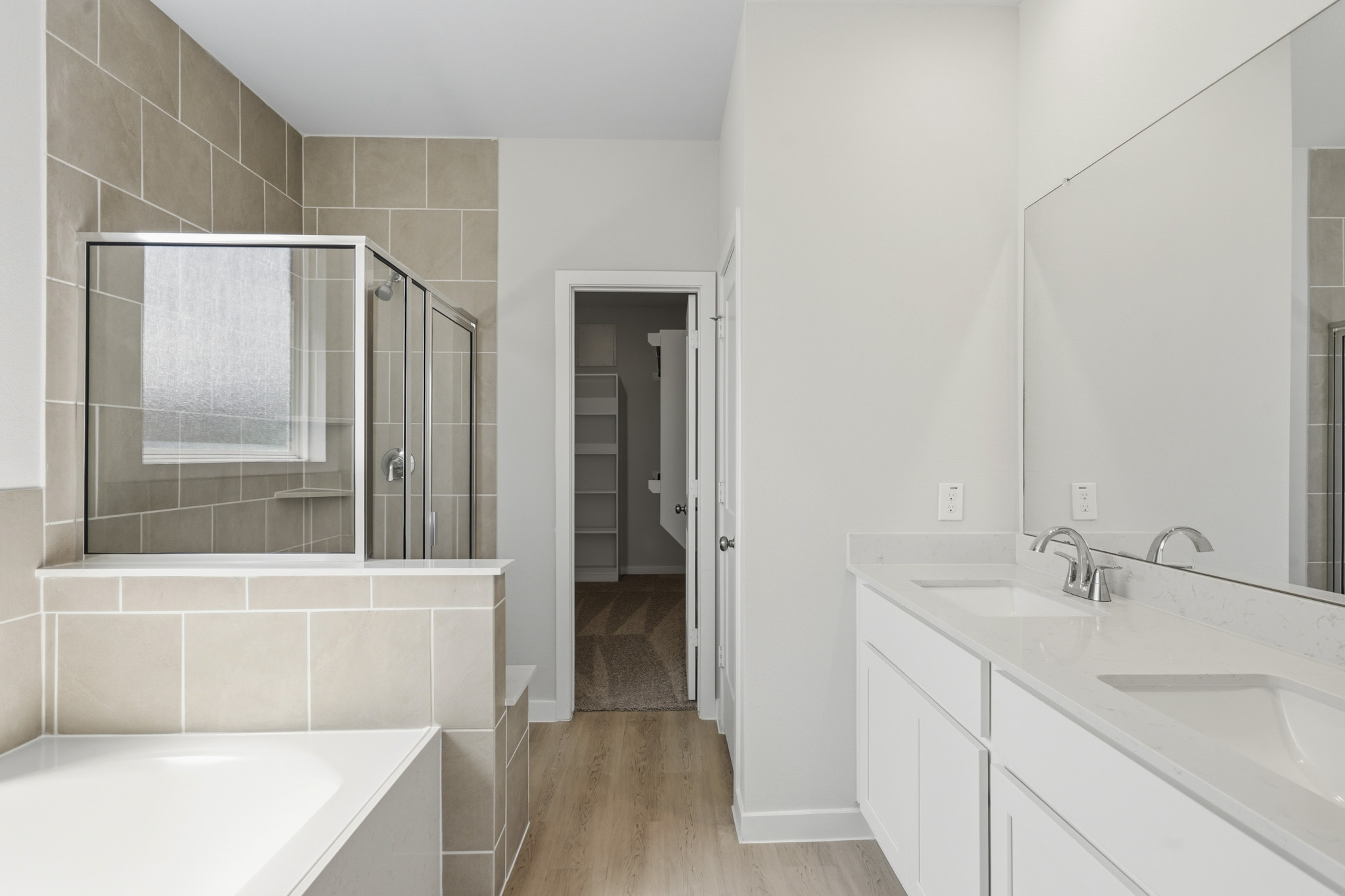 A bathroom with a tub sink and mirror.