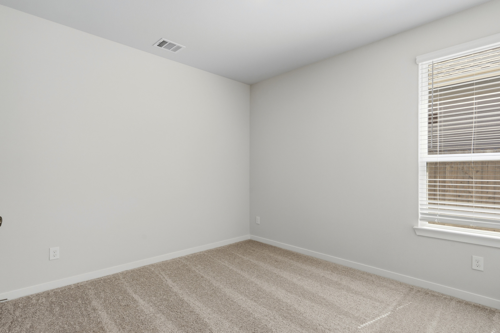 A room with a carpet and a window.