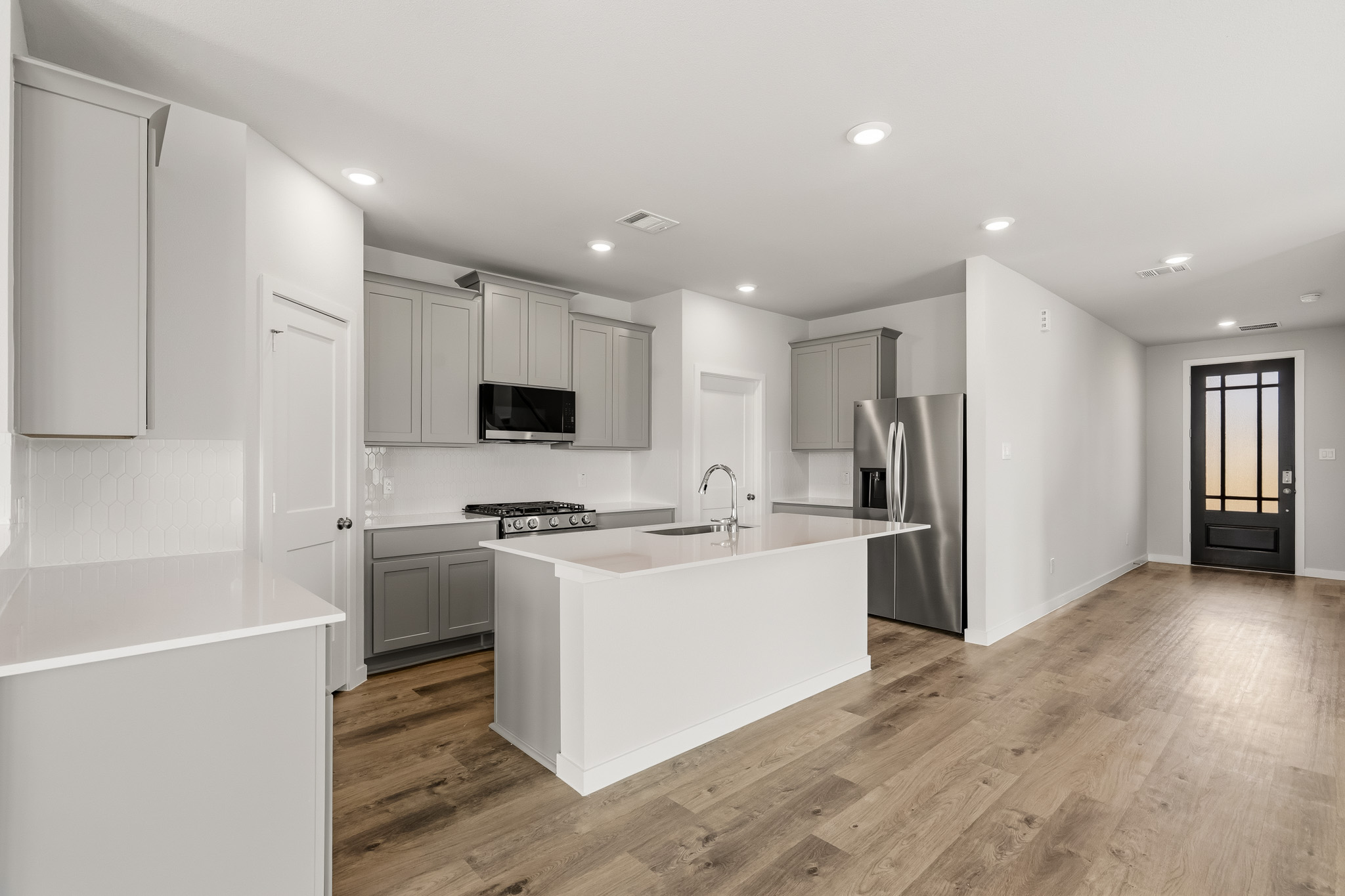 A kitchen with white cabinets.