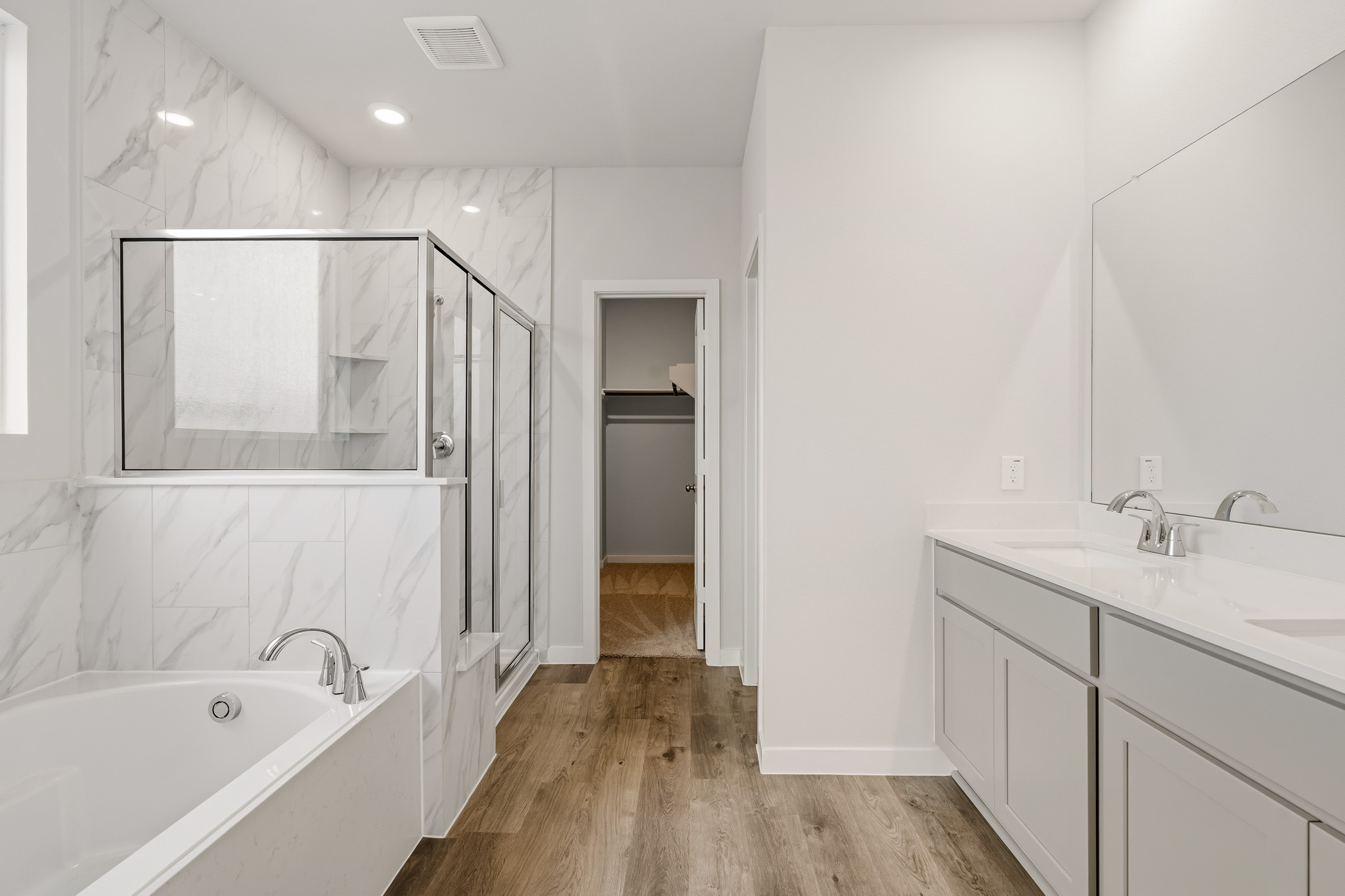 A bathroom with a tub sink and mirror.
