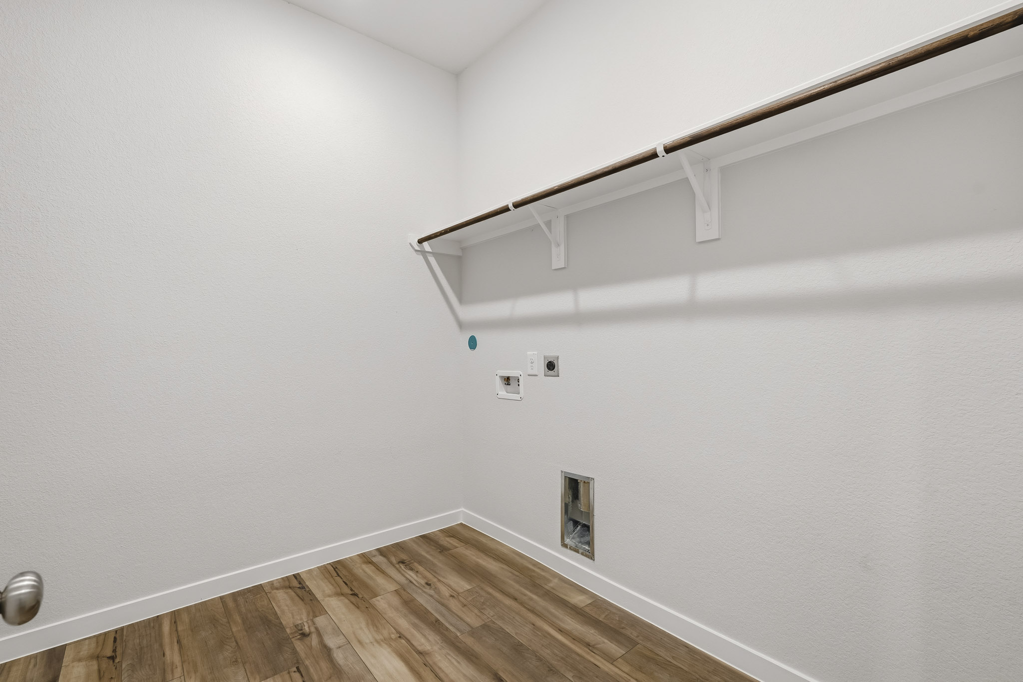 A white room with a wood floor and a wood floor.