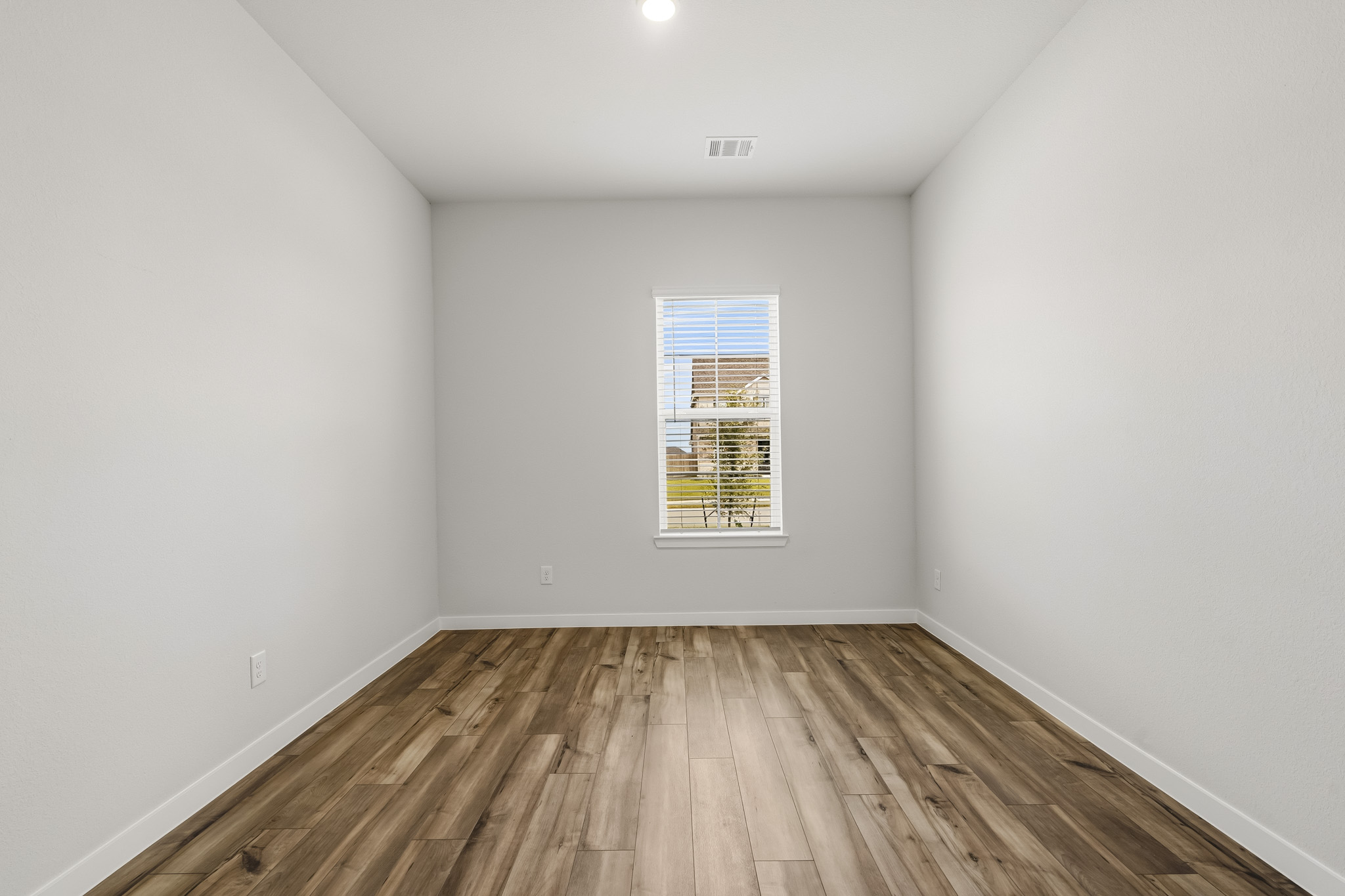 A room with a wood floor and a window.