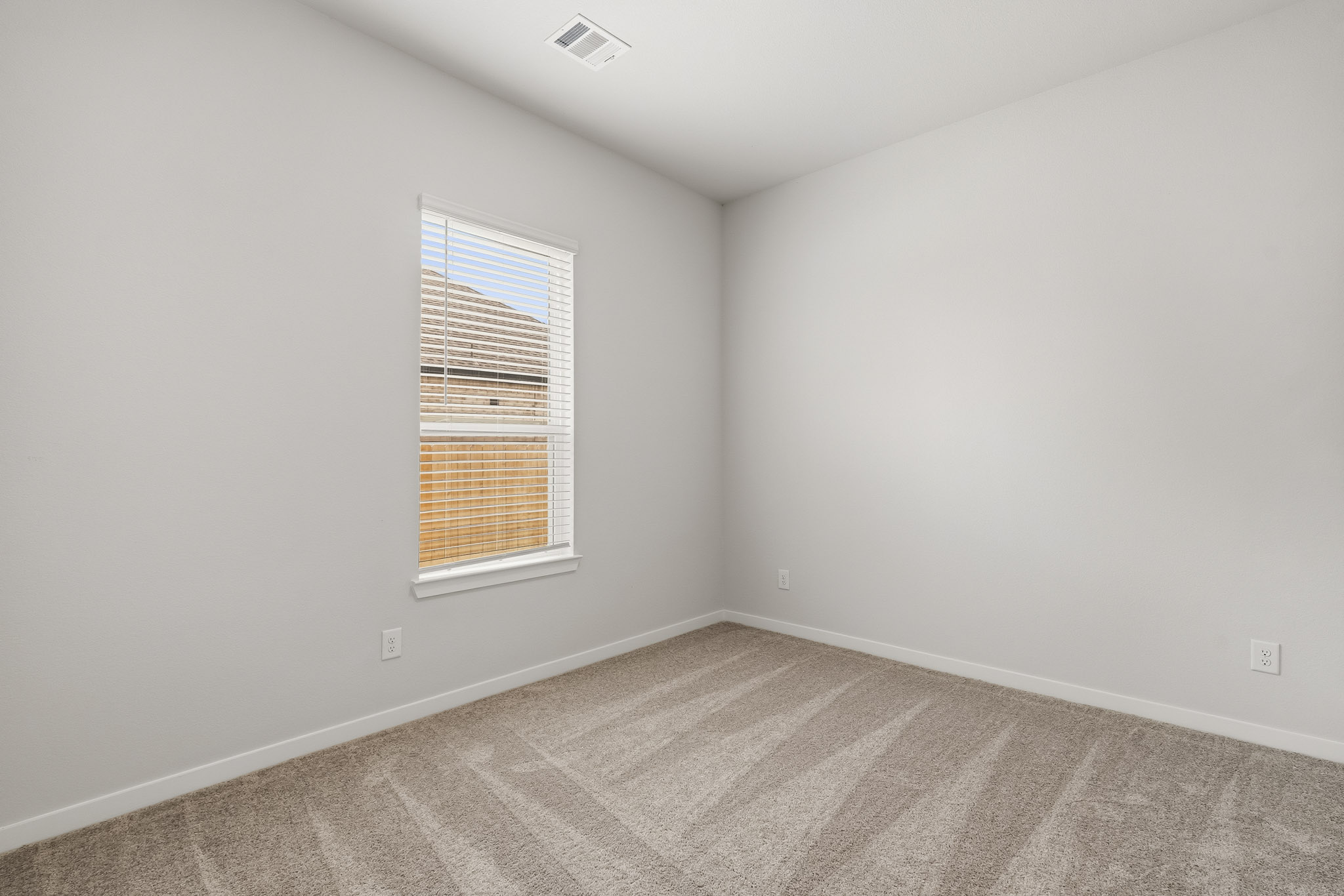 A room with a window and carpet.