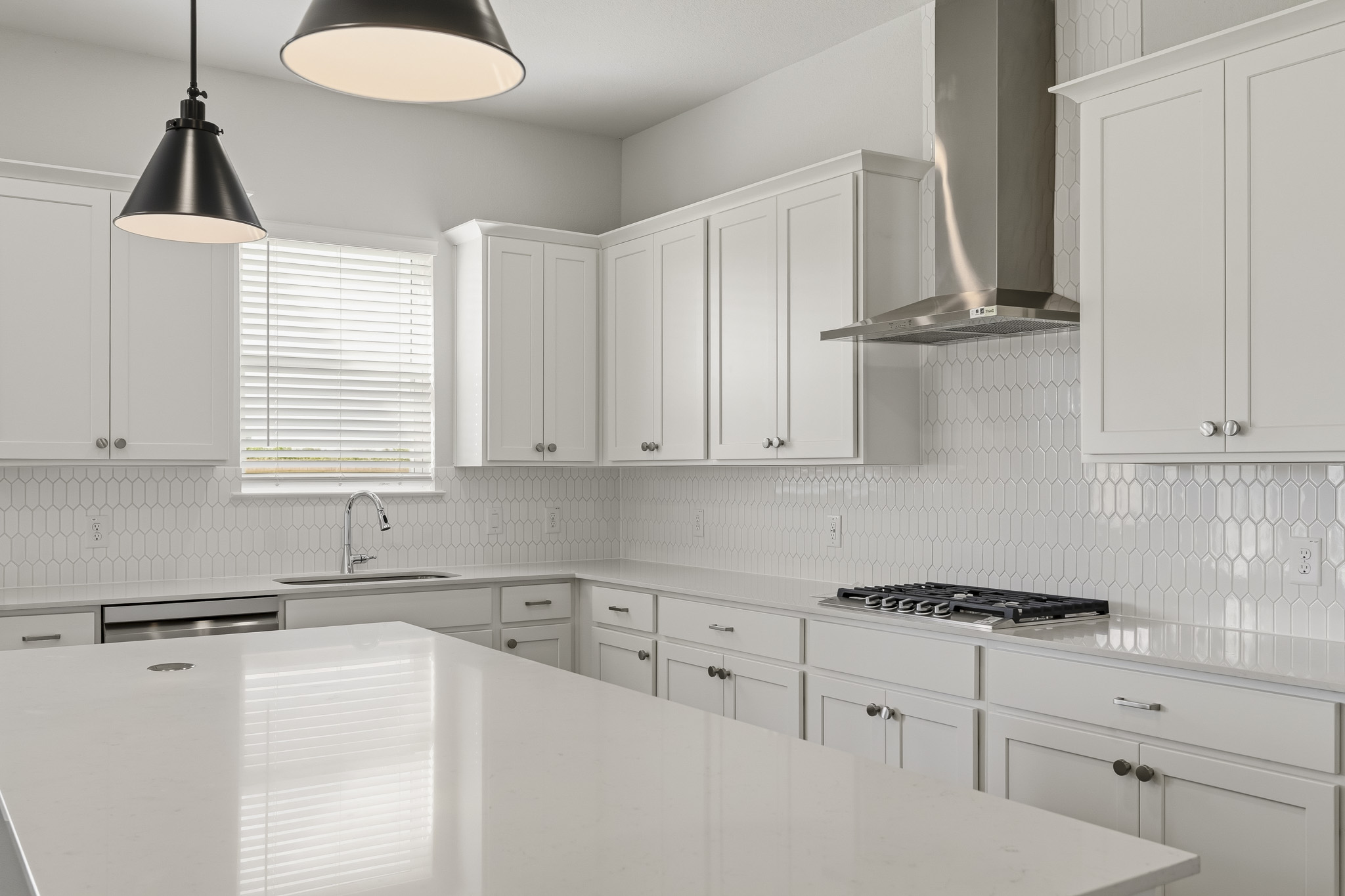 A kitchen with white cabinets.