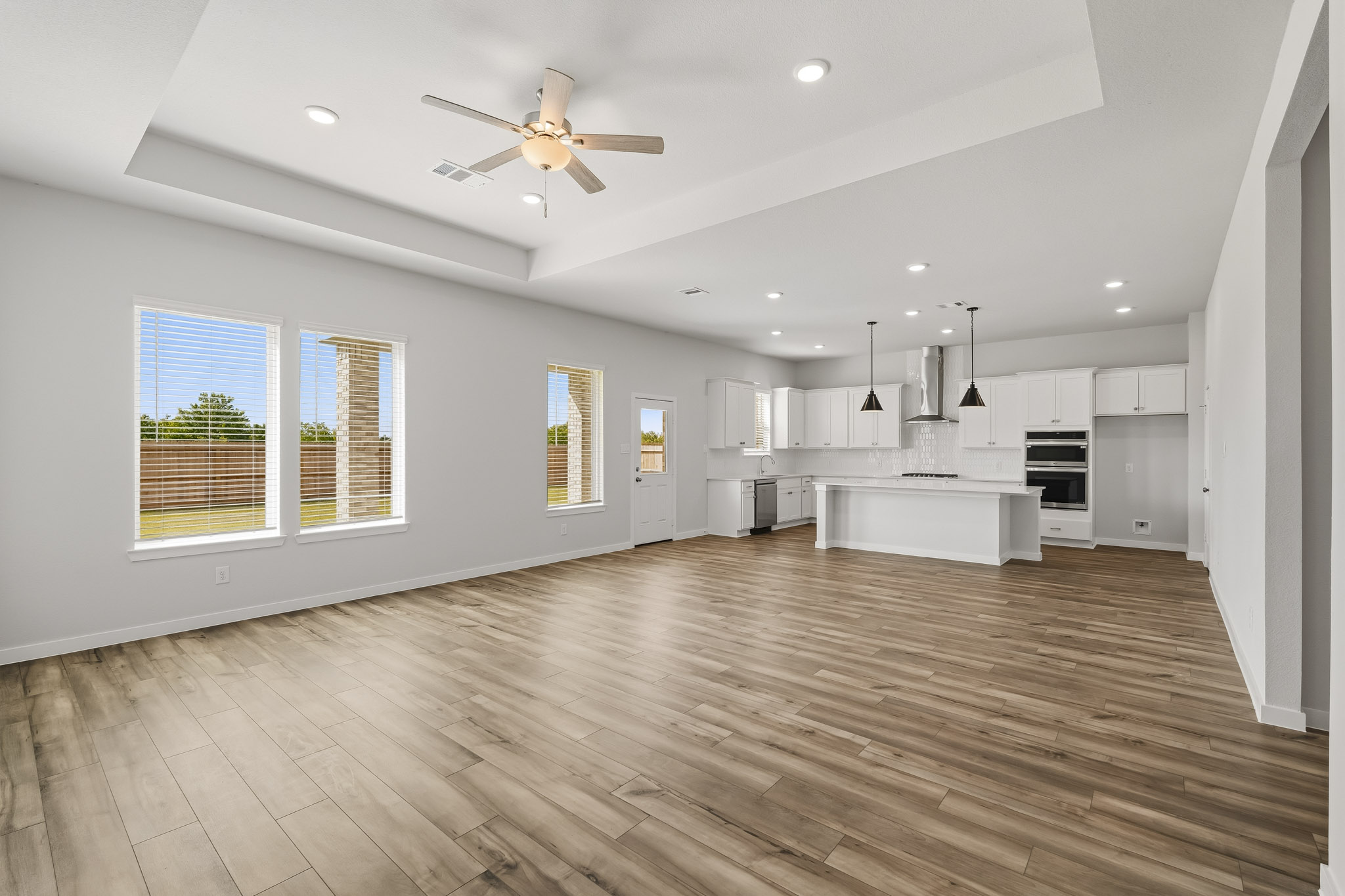 A large kitchen with a wood floor.