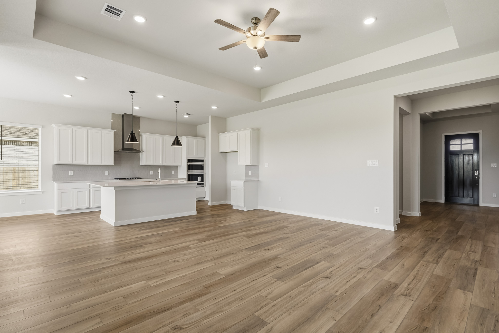 A large kitchen with a wood floor.