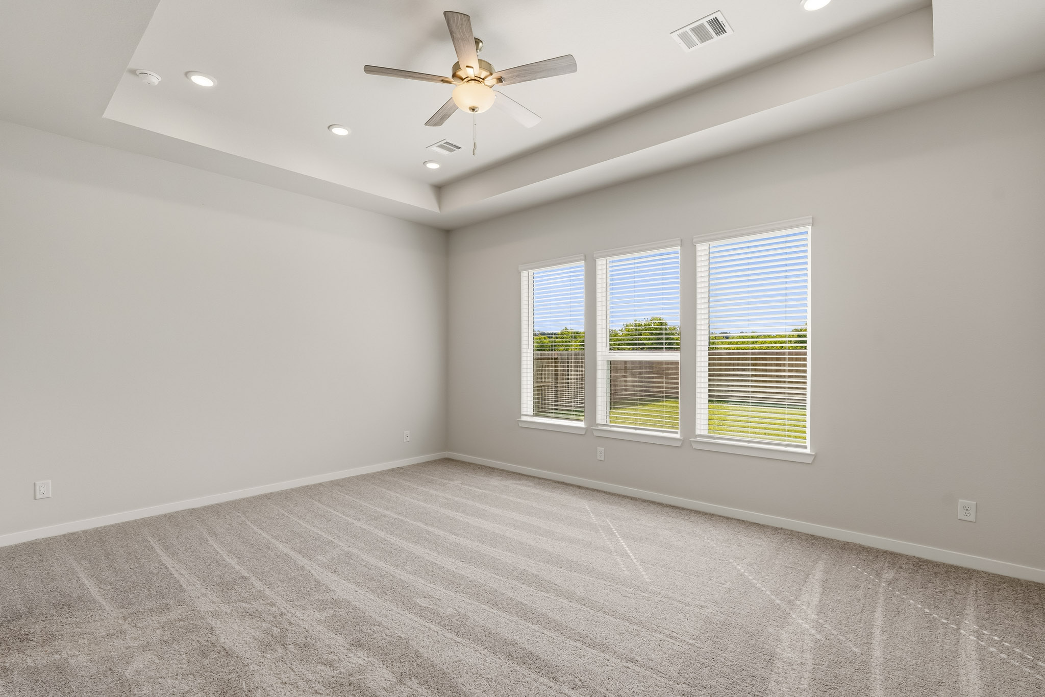A room with a ceiling fan and a window.