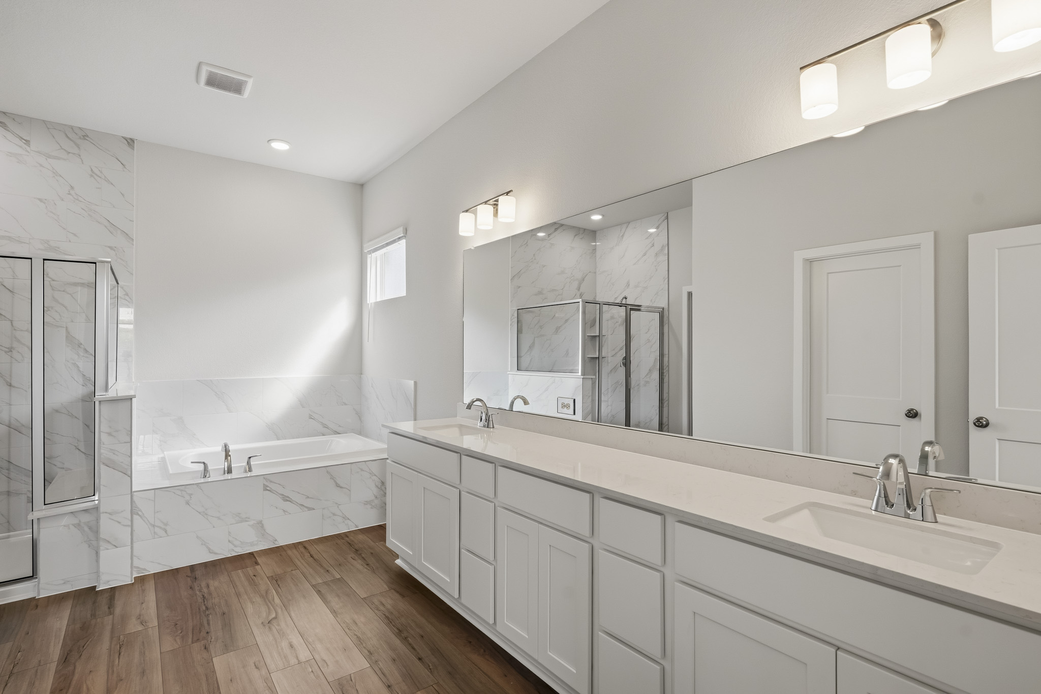 A bathroom with a large mirror.