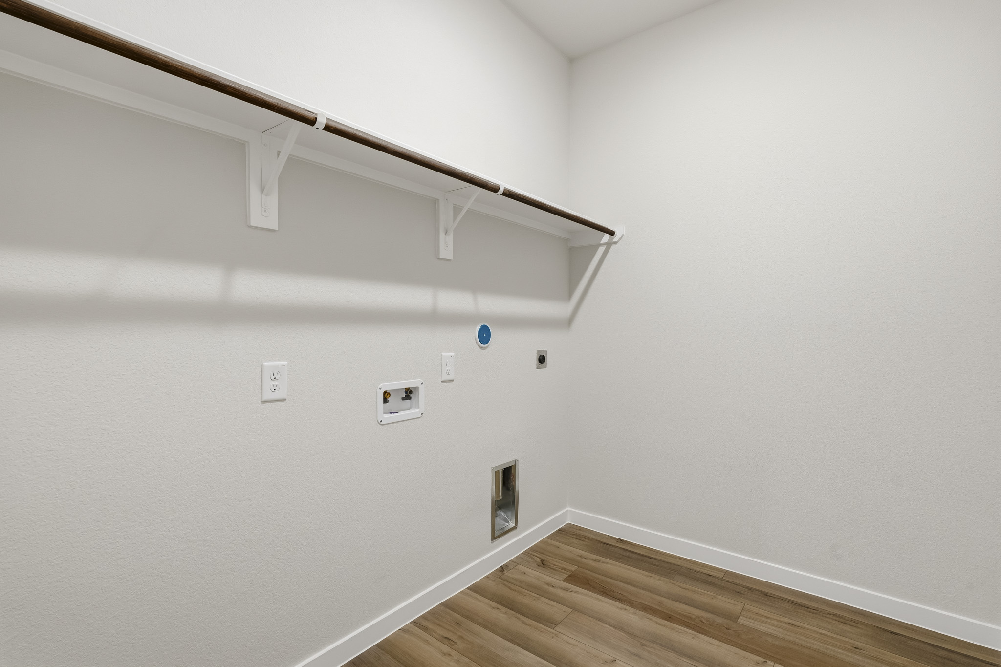 A white room with a wood floor and white walls.