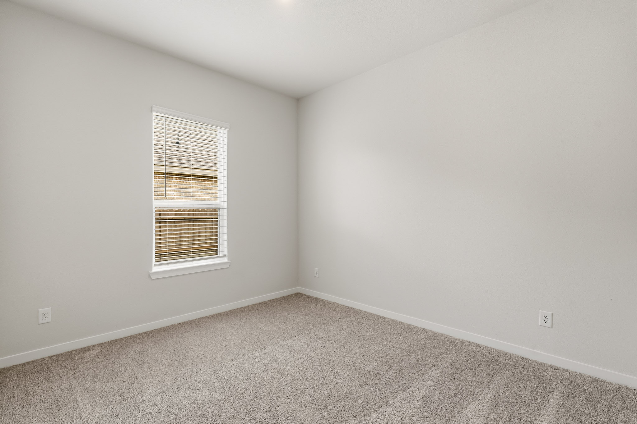 A room with a window and carpet.