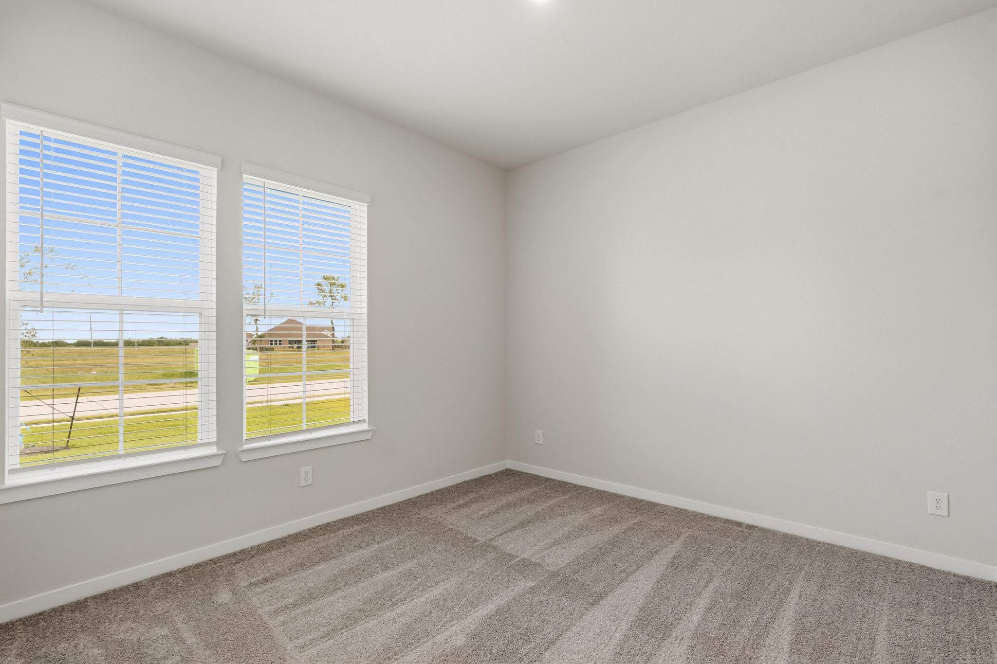 A room with windows and a rug.