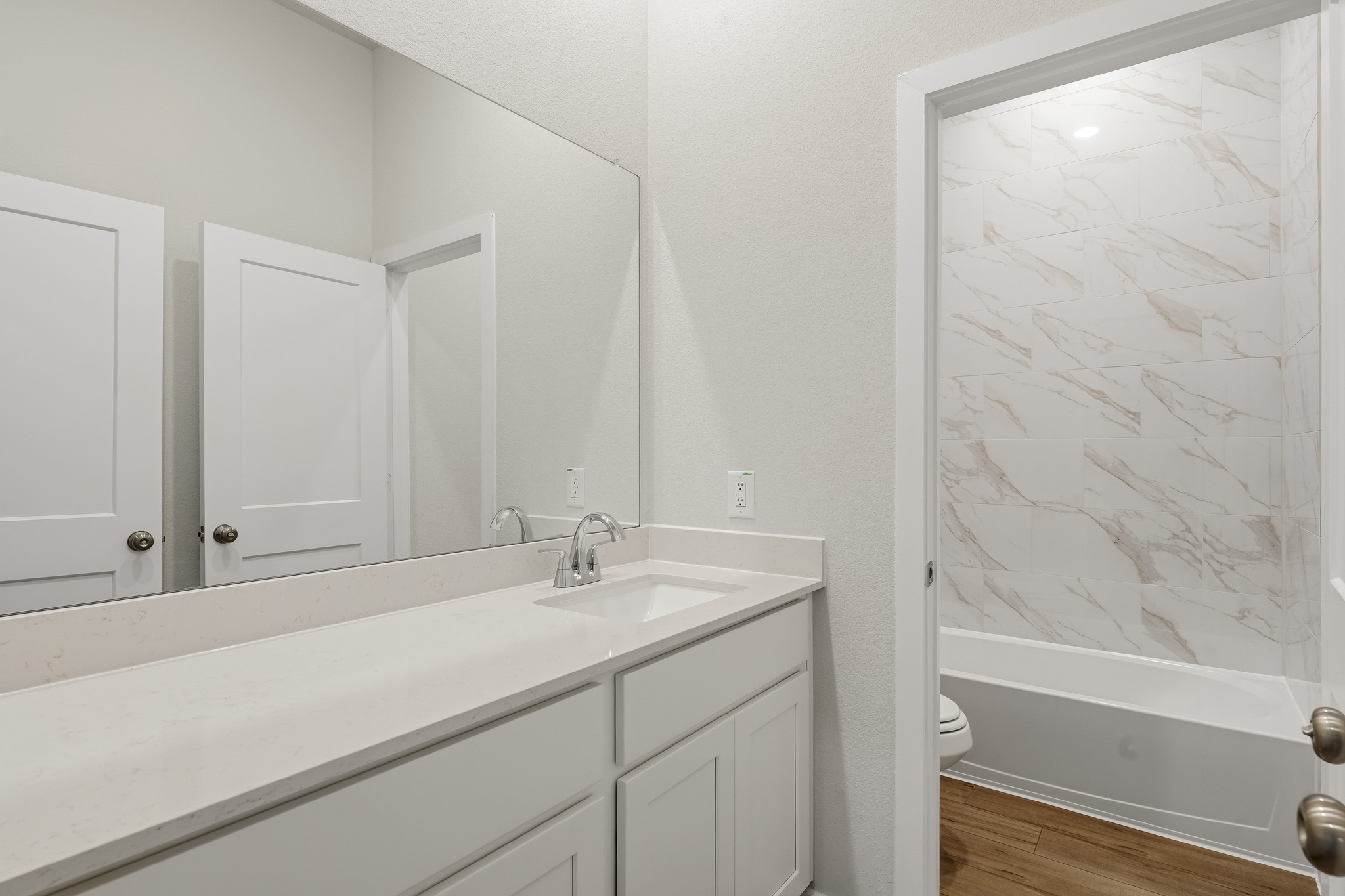 A bathroom with a tub sink and a toilet.