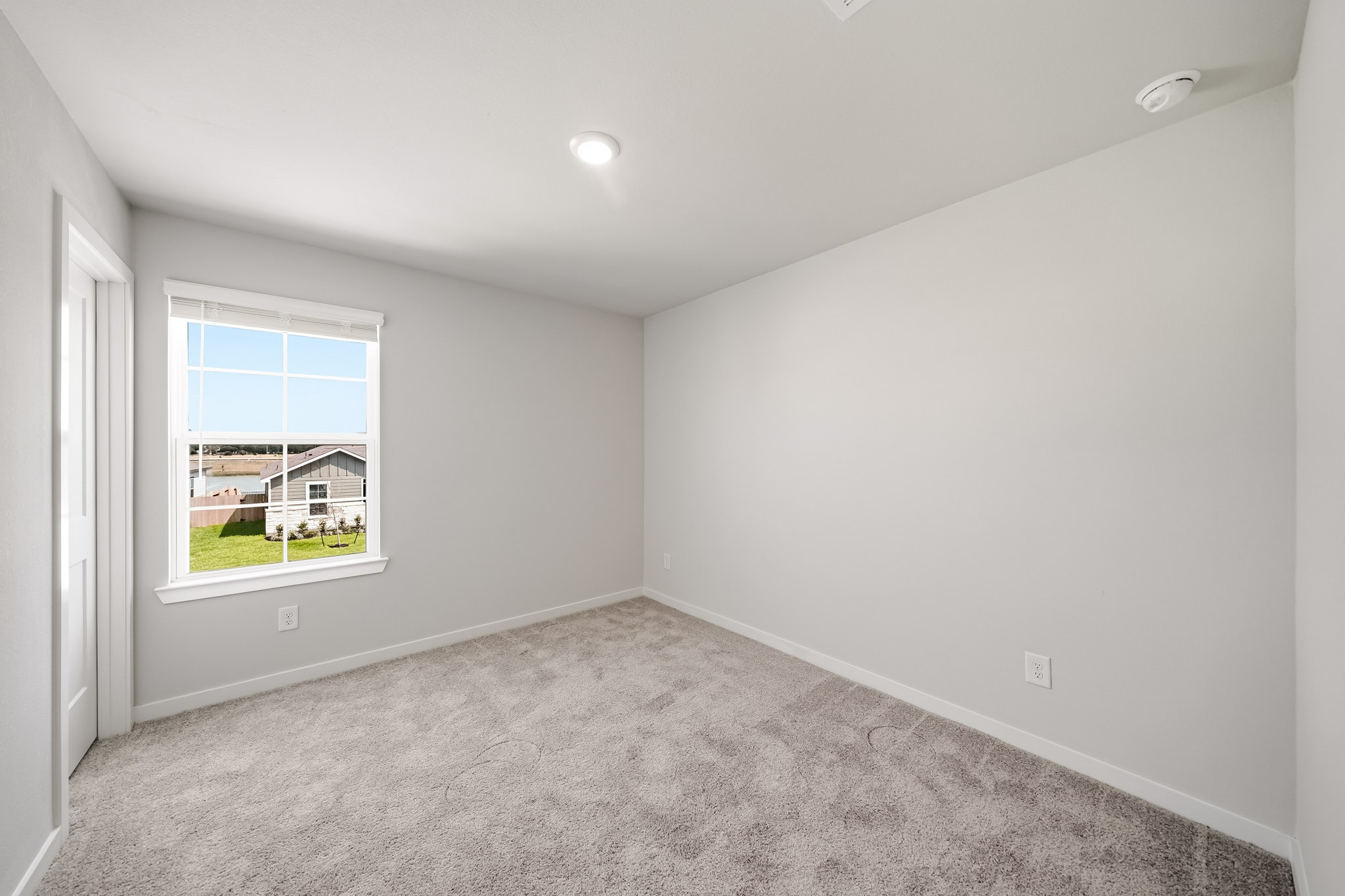 A room with a carpet and a window.