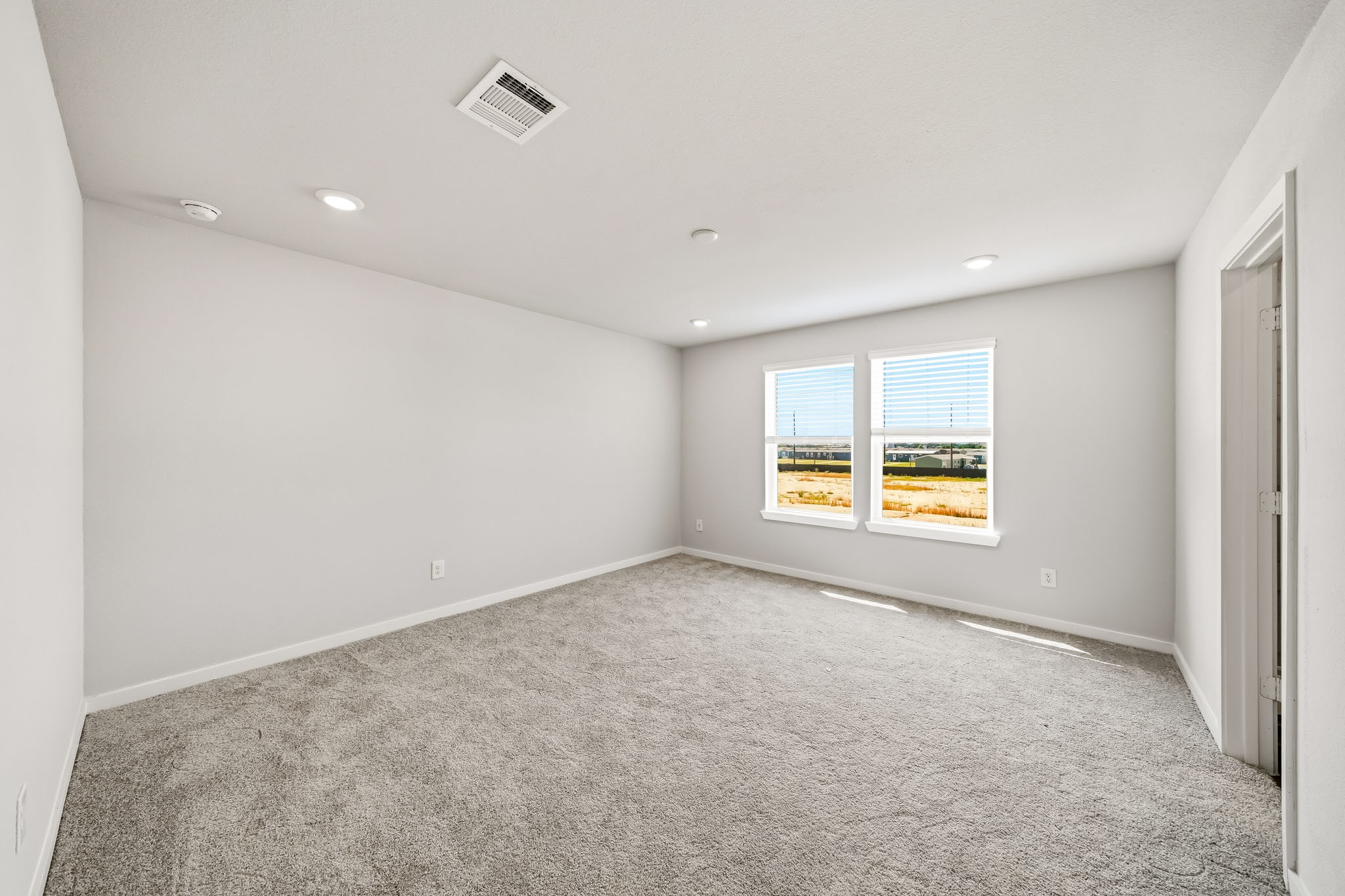 A room with a carpet and windows.