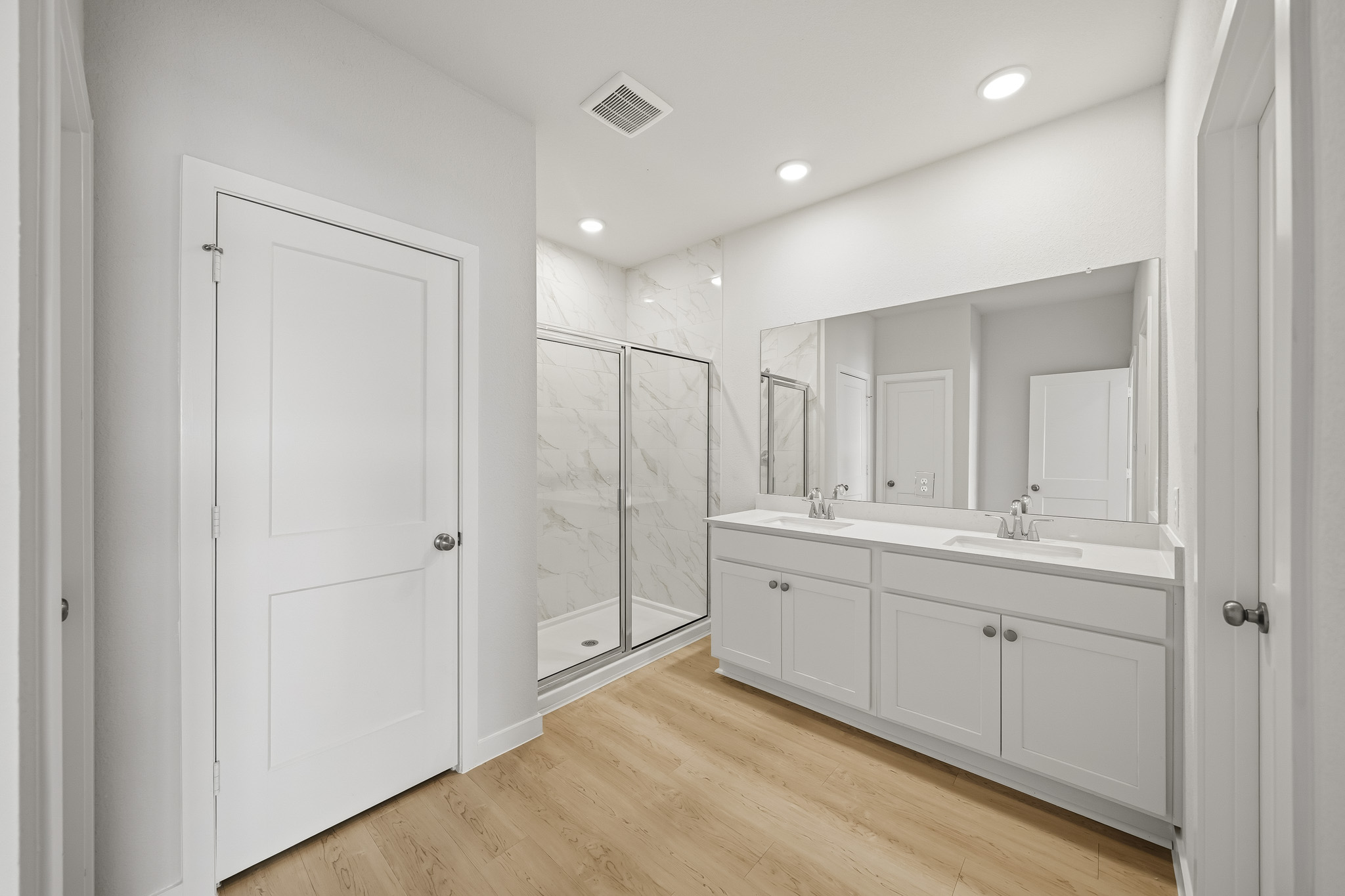 A bathroom with white cabinets.