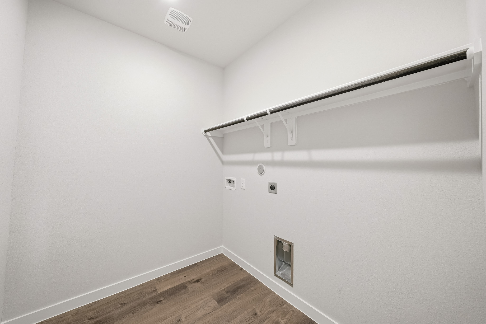 A white wall with a metal bar.