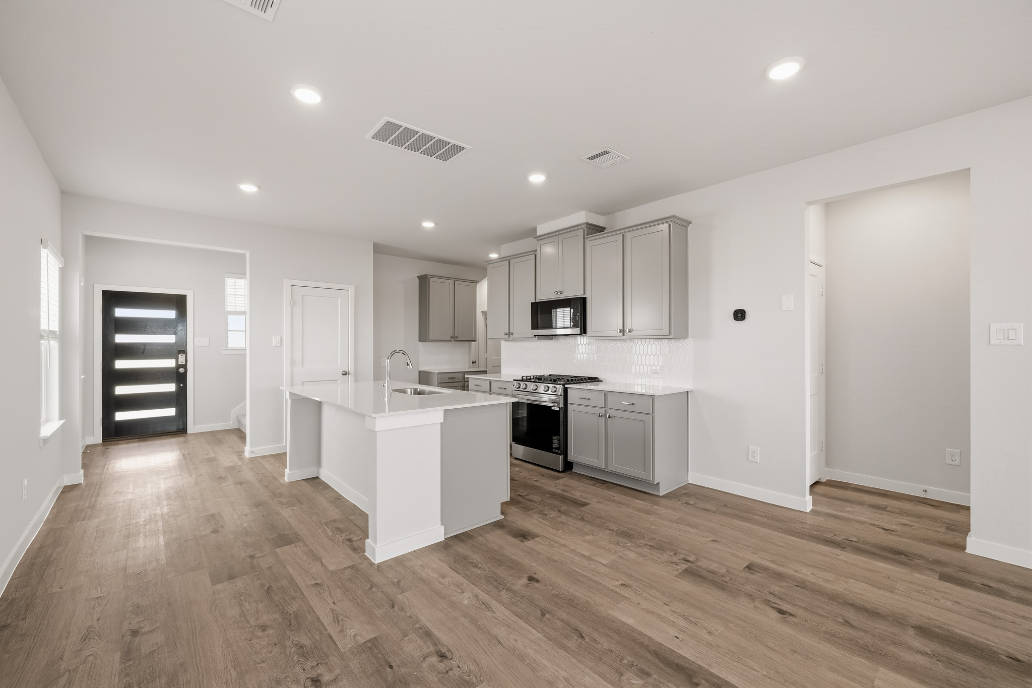 A kitchen with white cabinets.