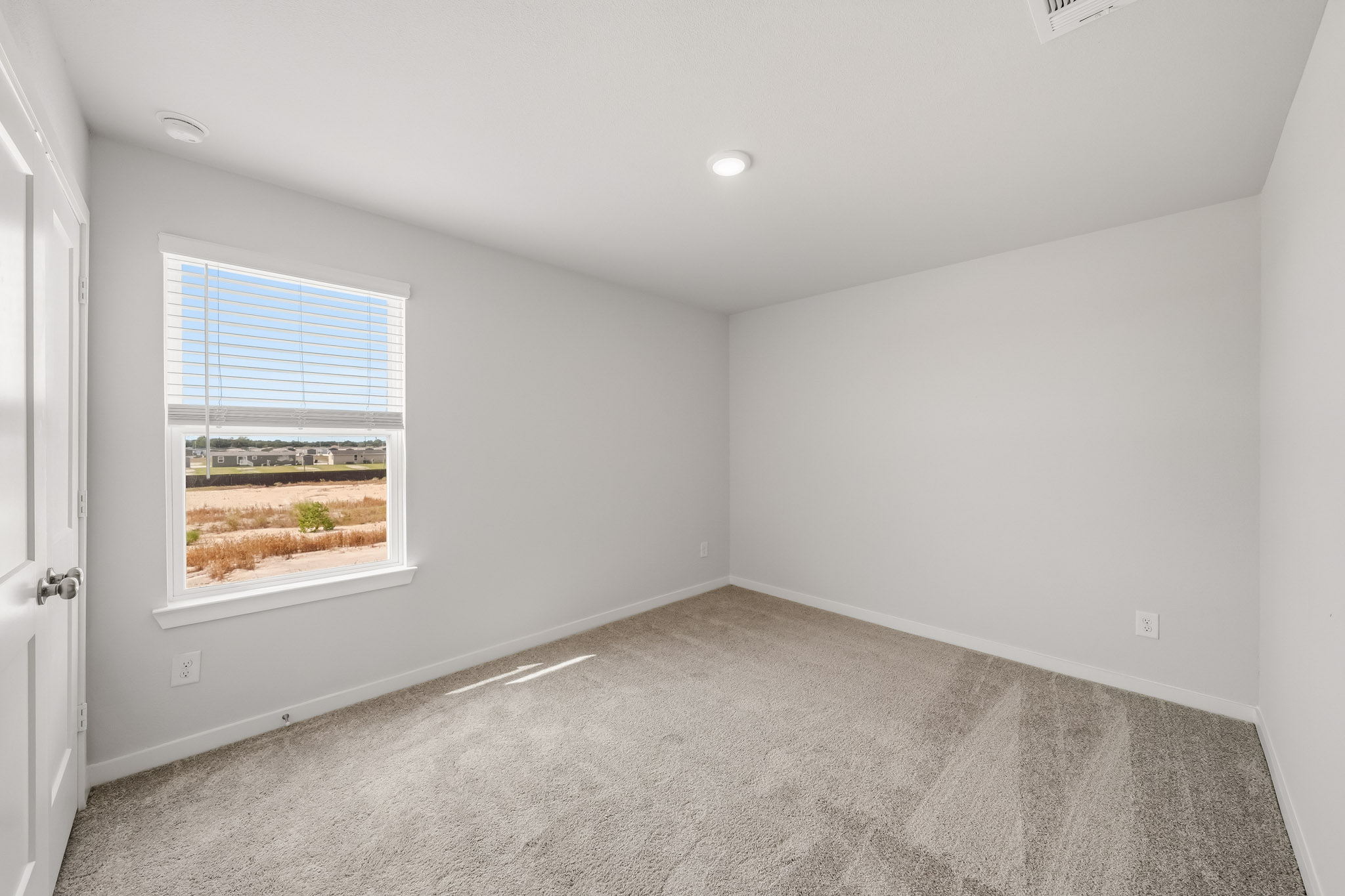 A room with a window and carpet.