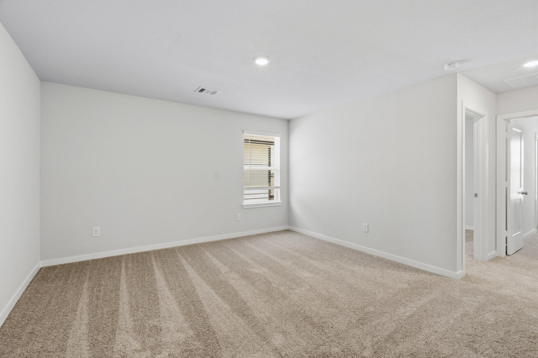 A room with a carpet and a door.