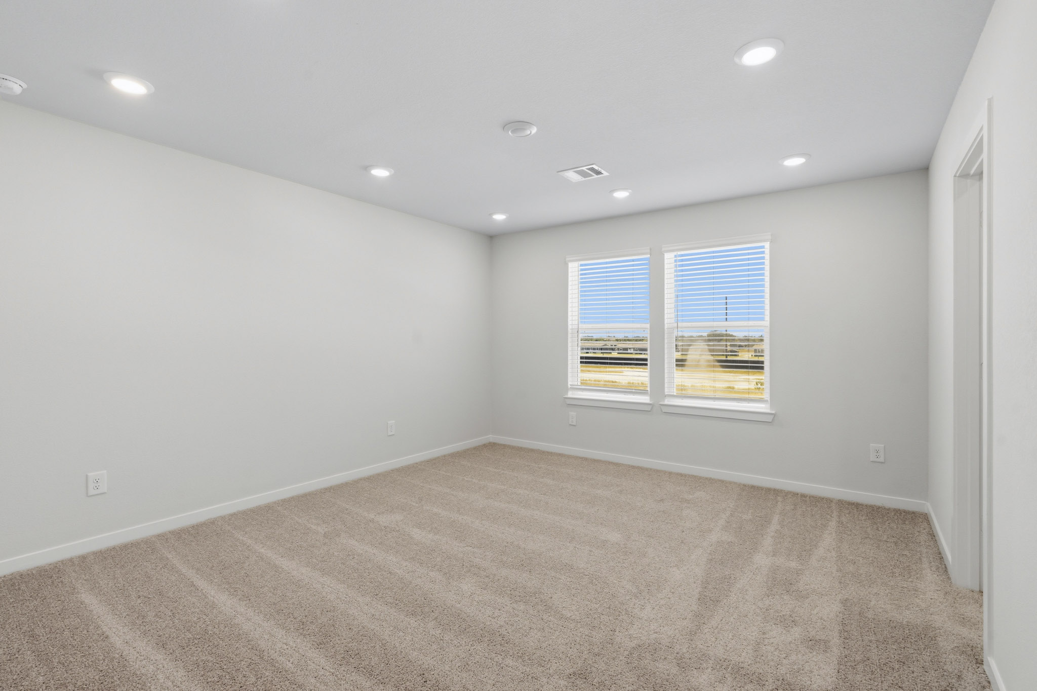 A room with a carpet and windows.