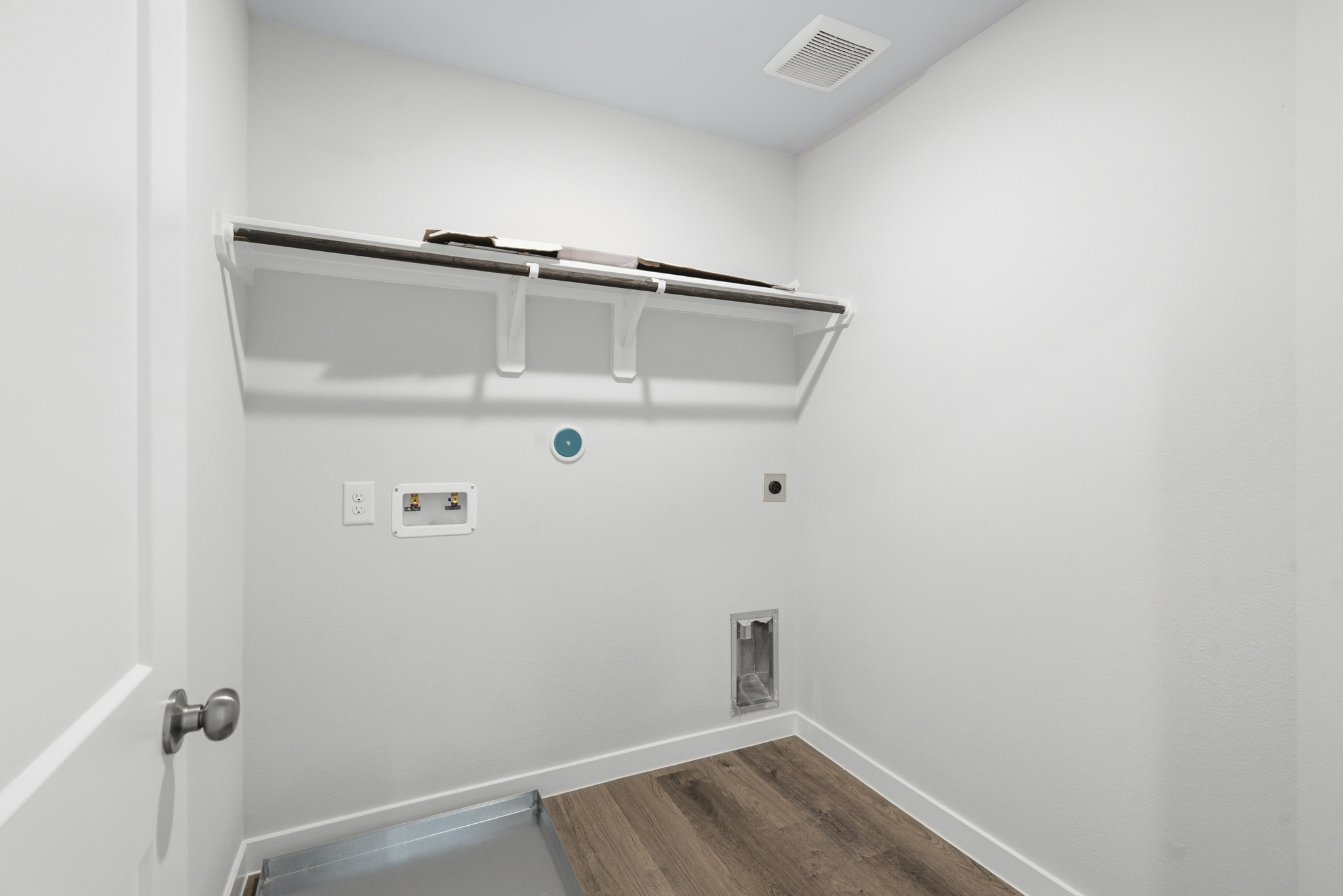 A white wall with a metal bar.