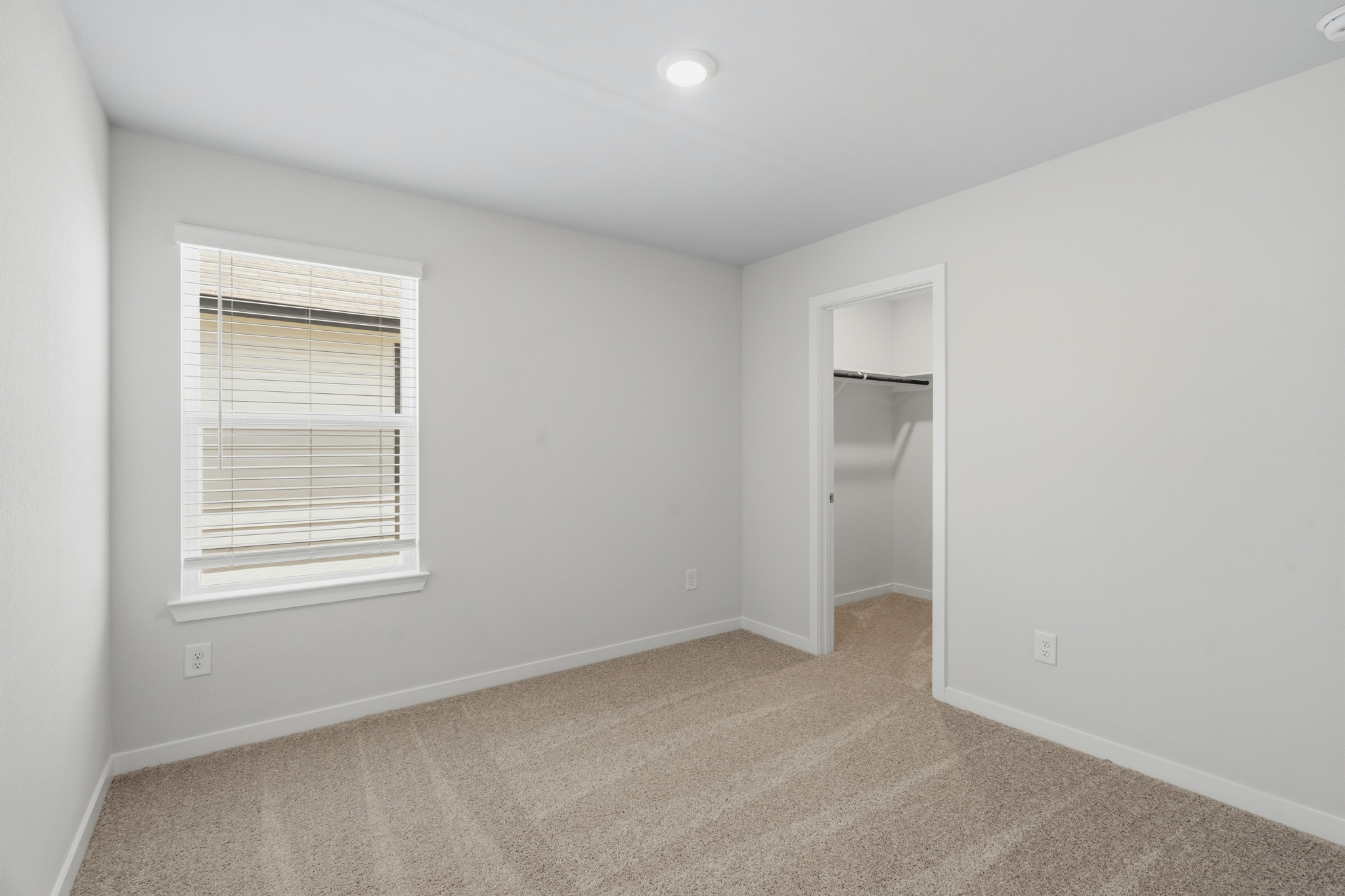 A room with a shelf and a window.