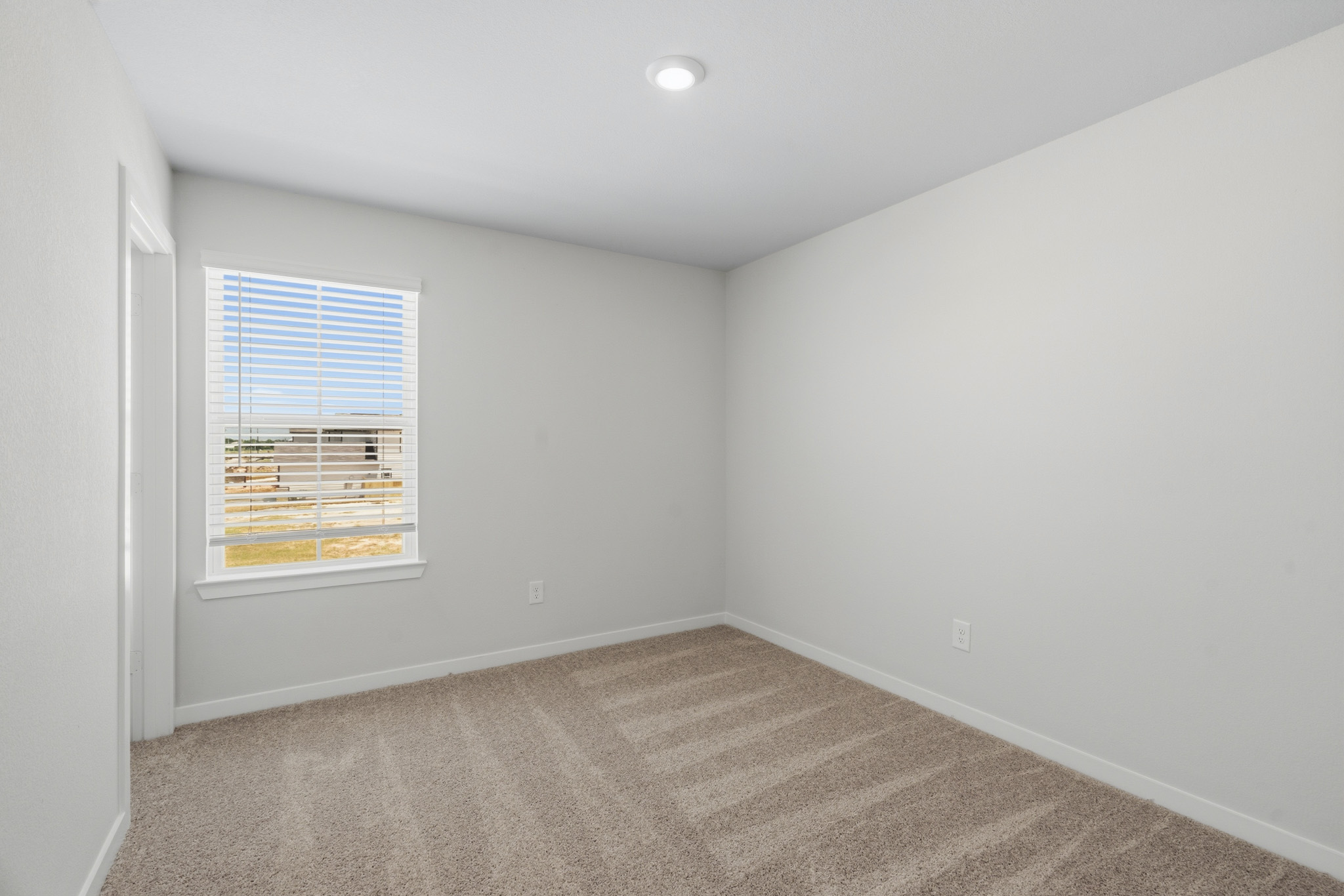 A room with a window and a carpet.
