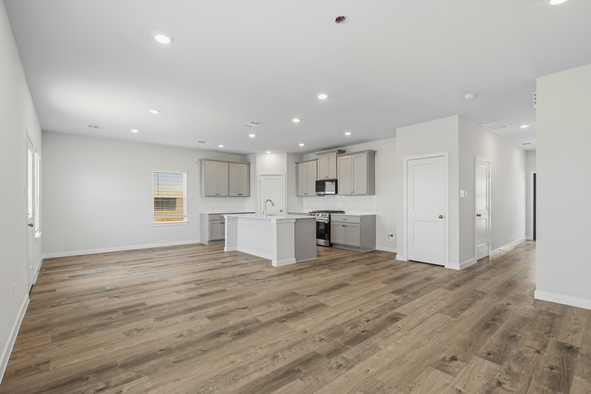 A large empty room with white cabinets.
