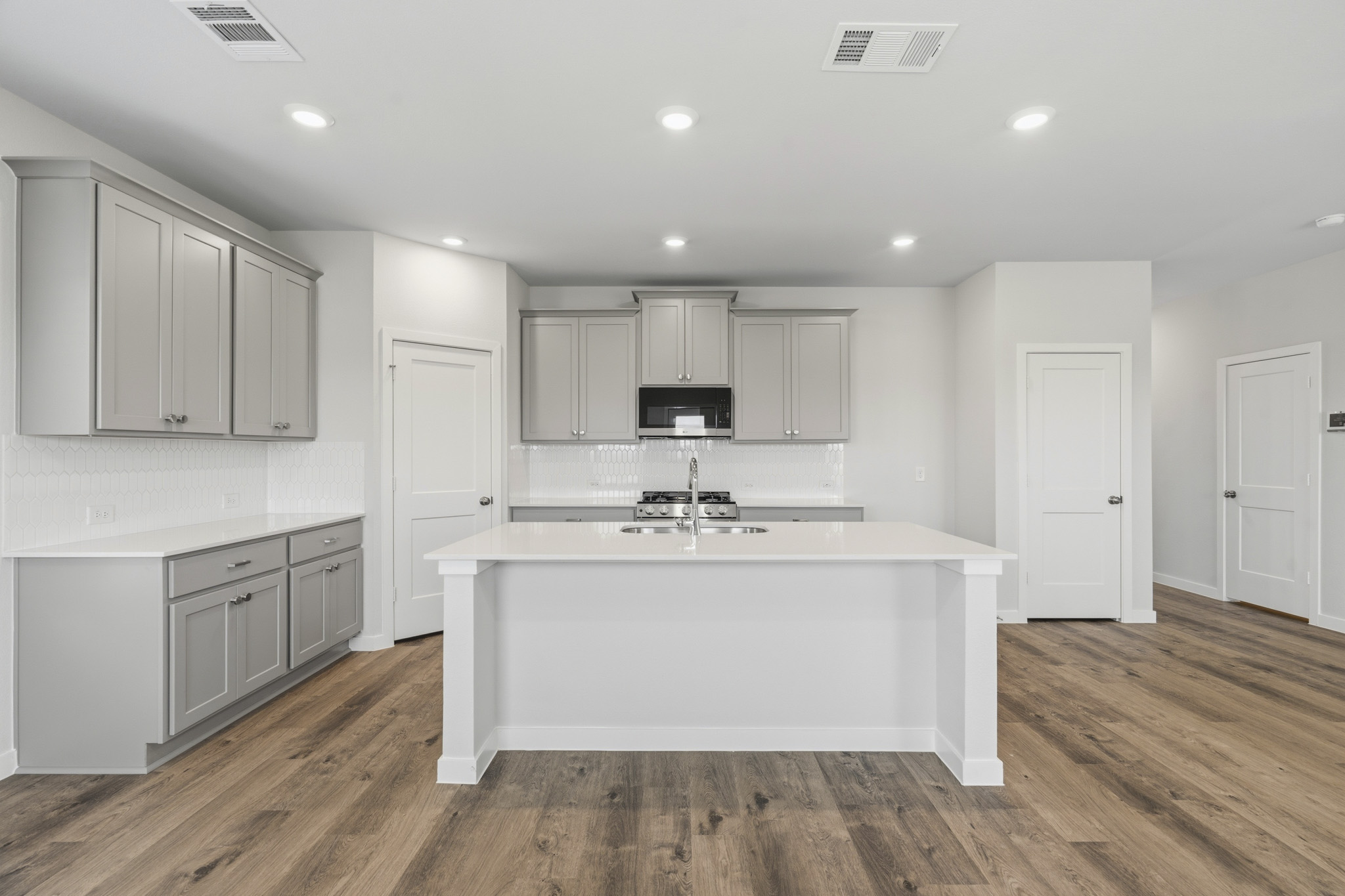A kitchen with white cabinets.
