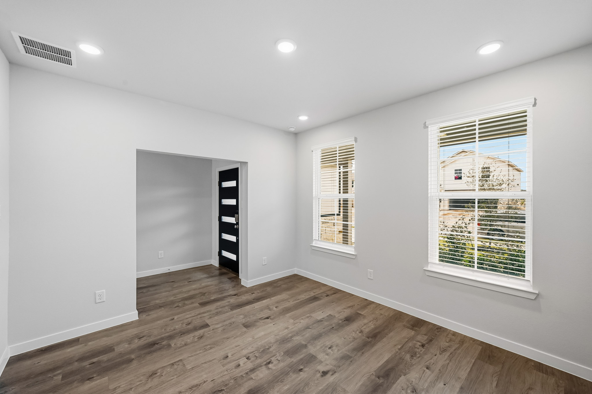 A room with a wood floor and windows.