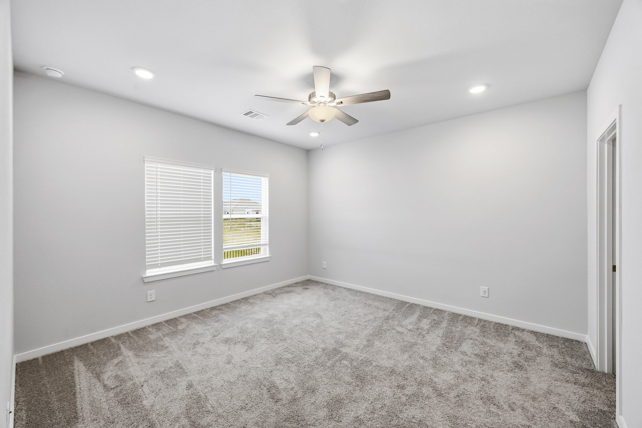 A room with a ceiling fan and a window.