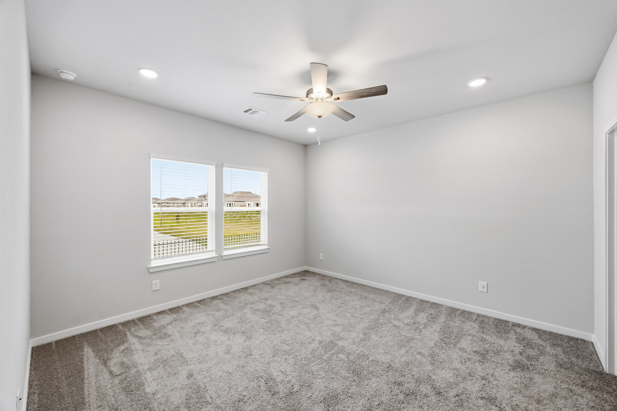 A room with a ceiling fan and a window.