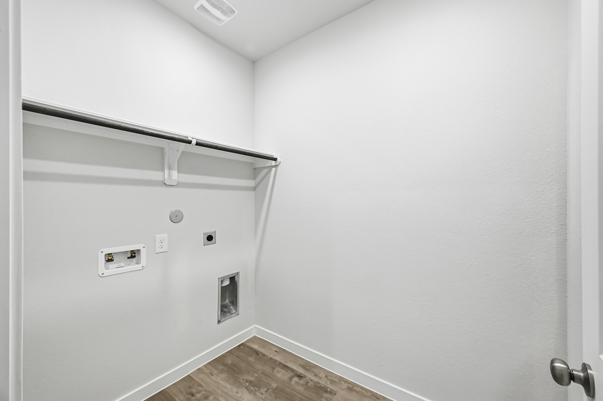 A white wall with a wood floor.