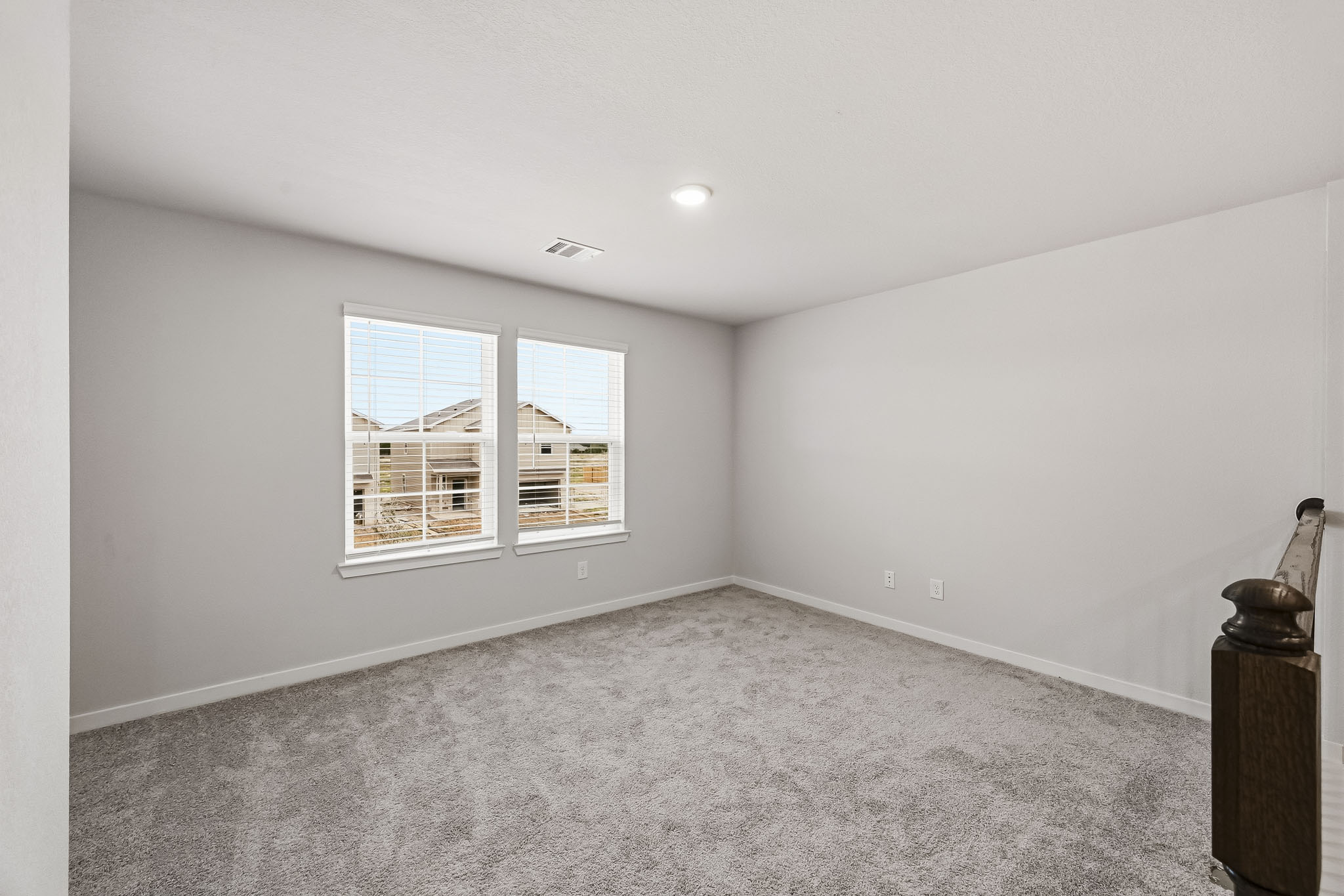 A room with a window and a rug.