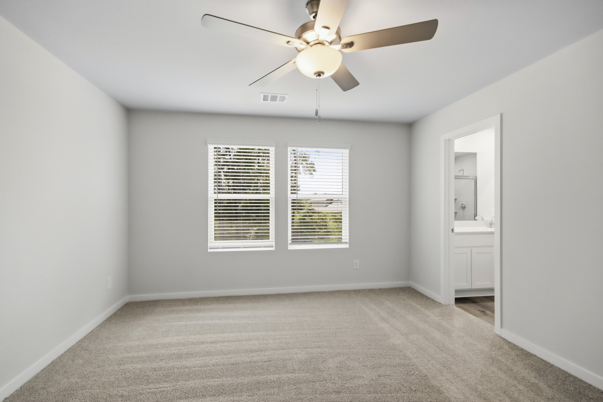 A room with a ceiling fan and a window.