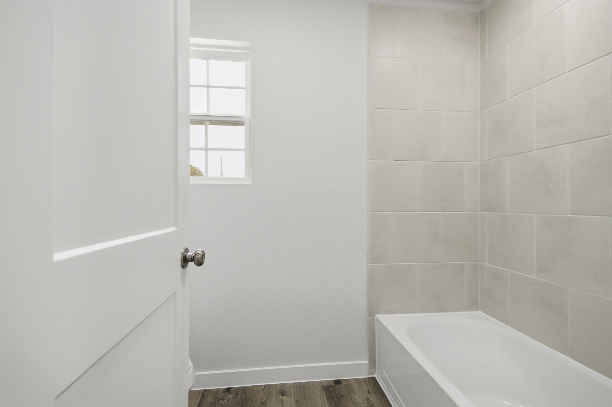 A bathroom with a tub and a window.