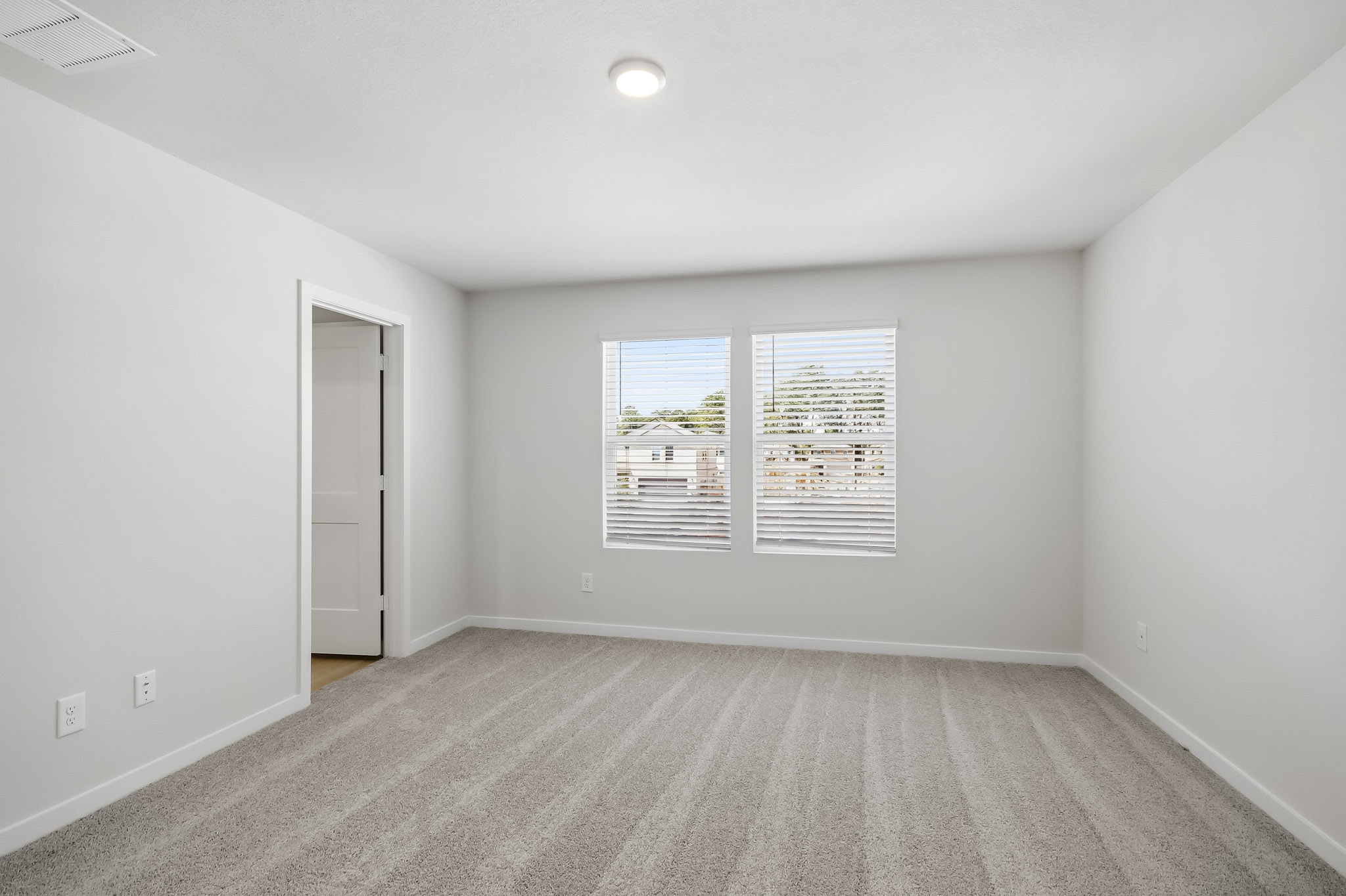 A room with a white wall and a door with a picture on it.