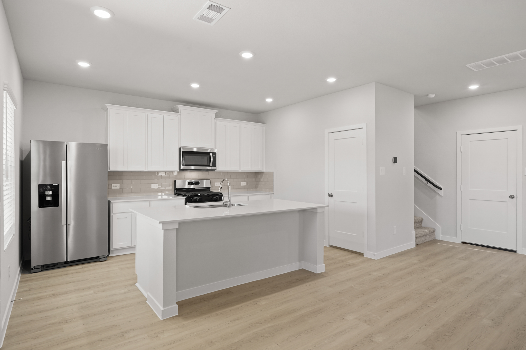 A kitchen with white cabinets.
