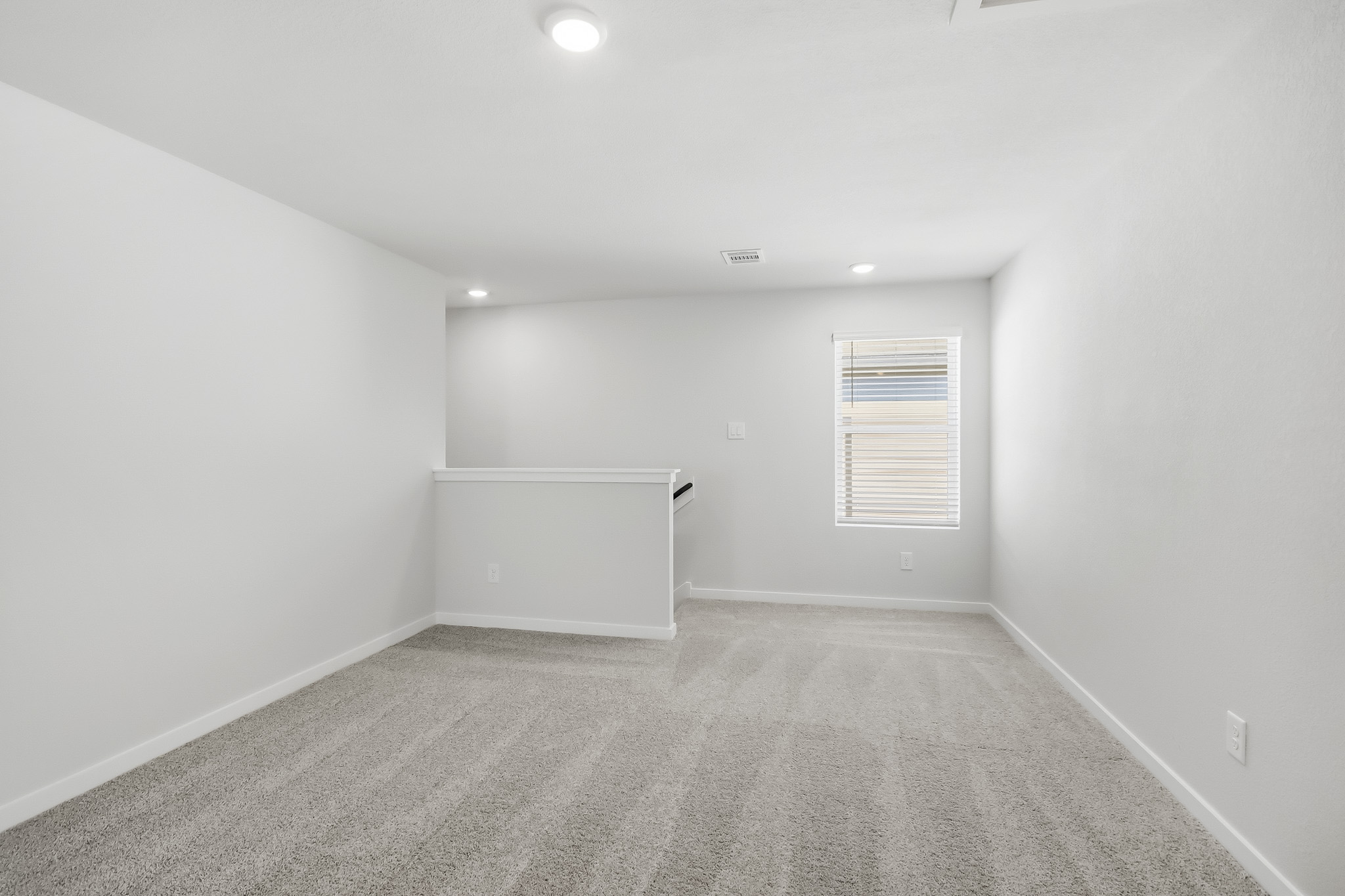 A room with a white wall and a window.