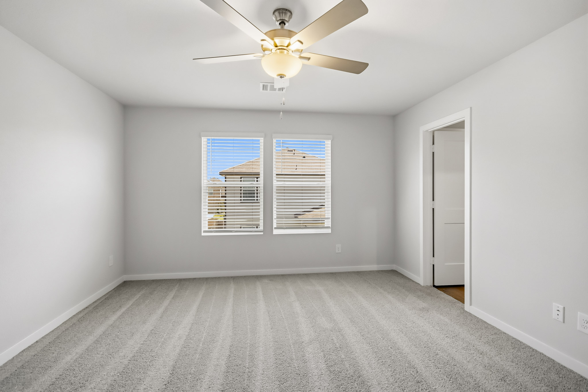 A room with a ceiling fan and a window.