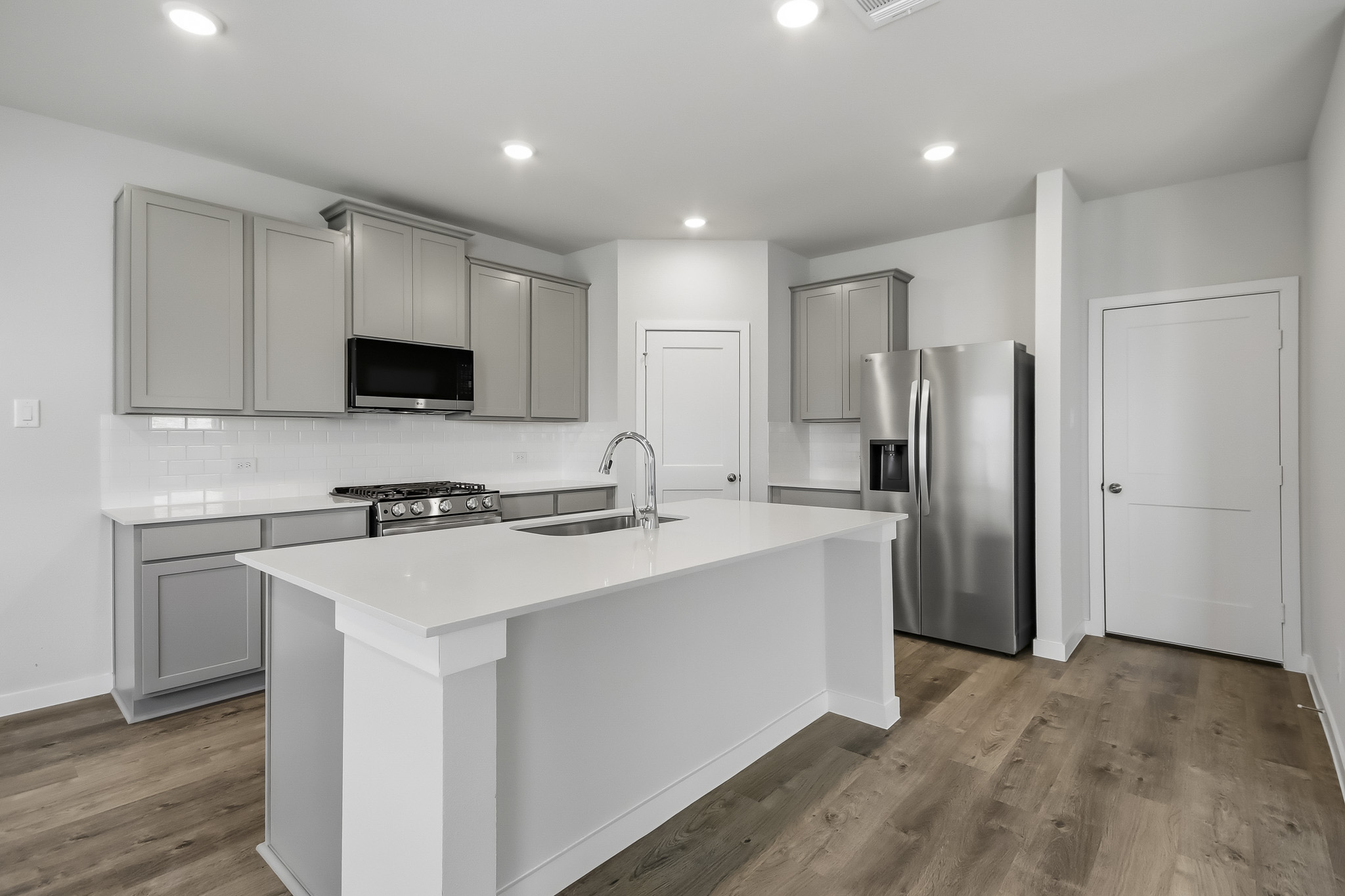 A kitchen with white cabinets.