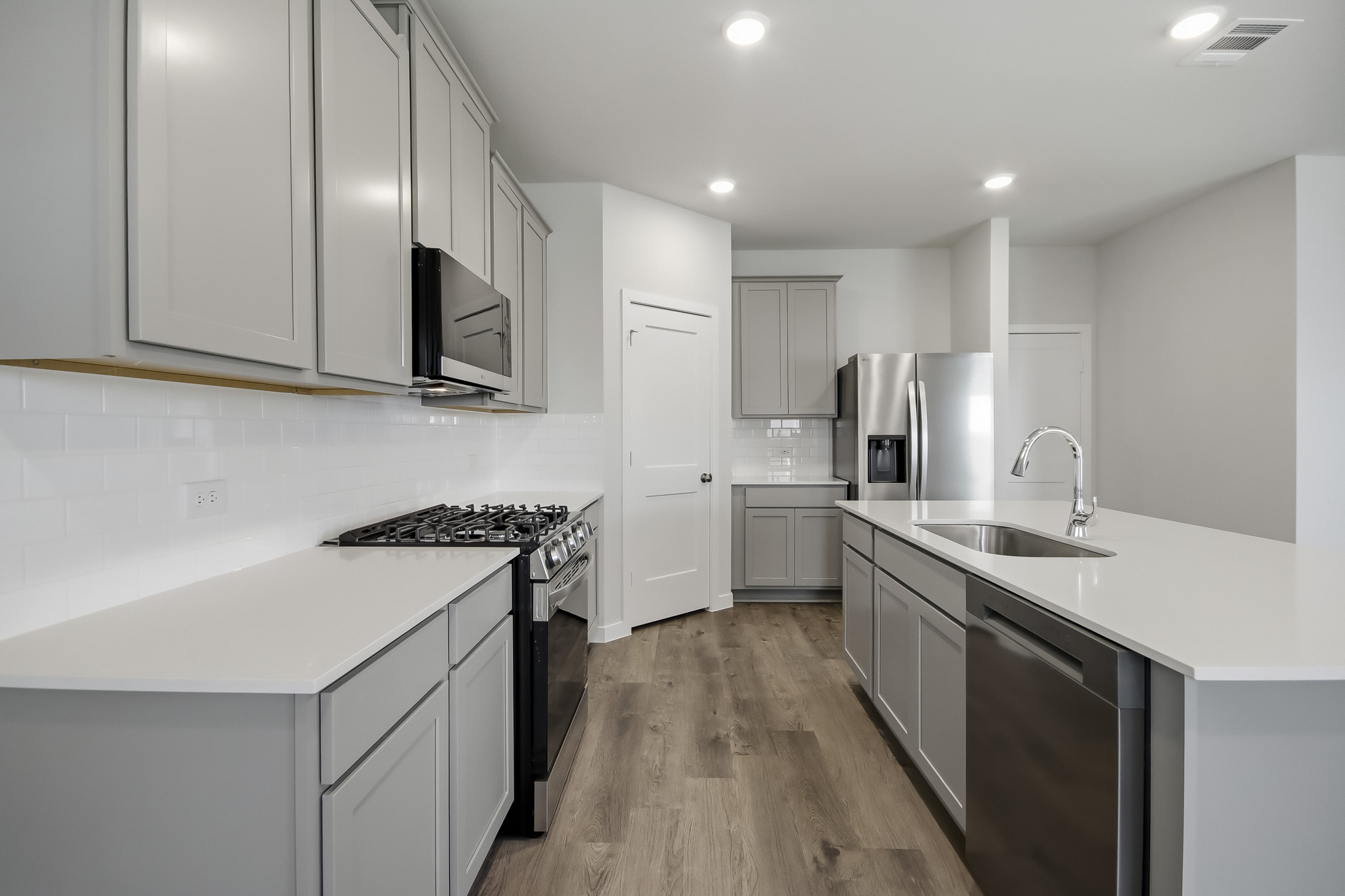 A kitchen with white cabinets.