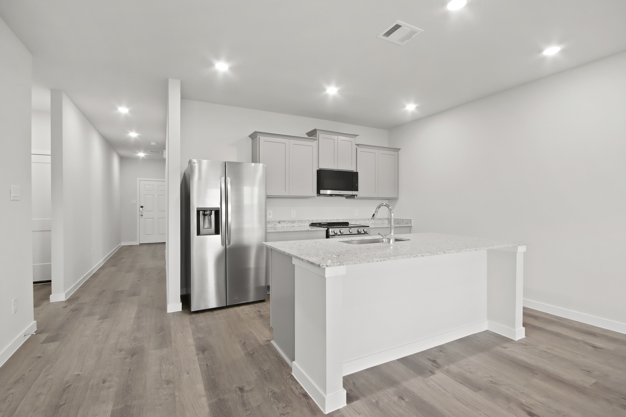 A kitchen with white cabinets.