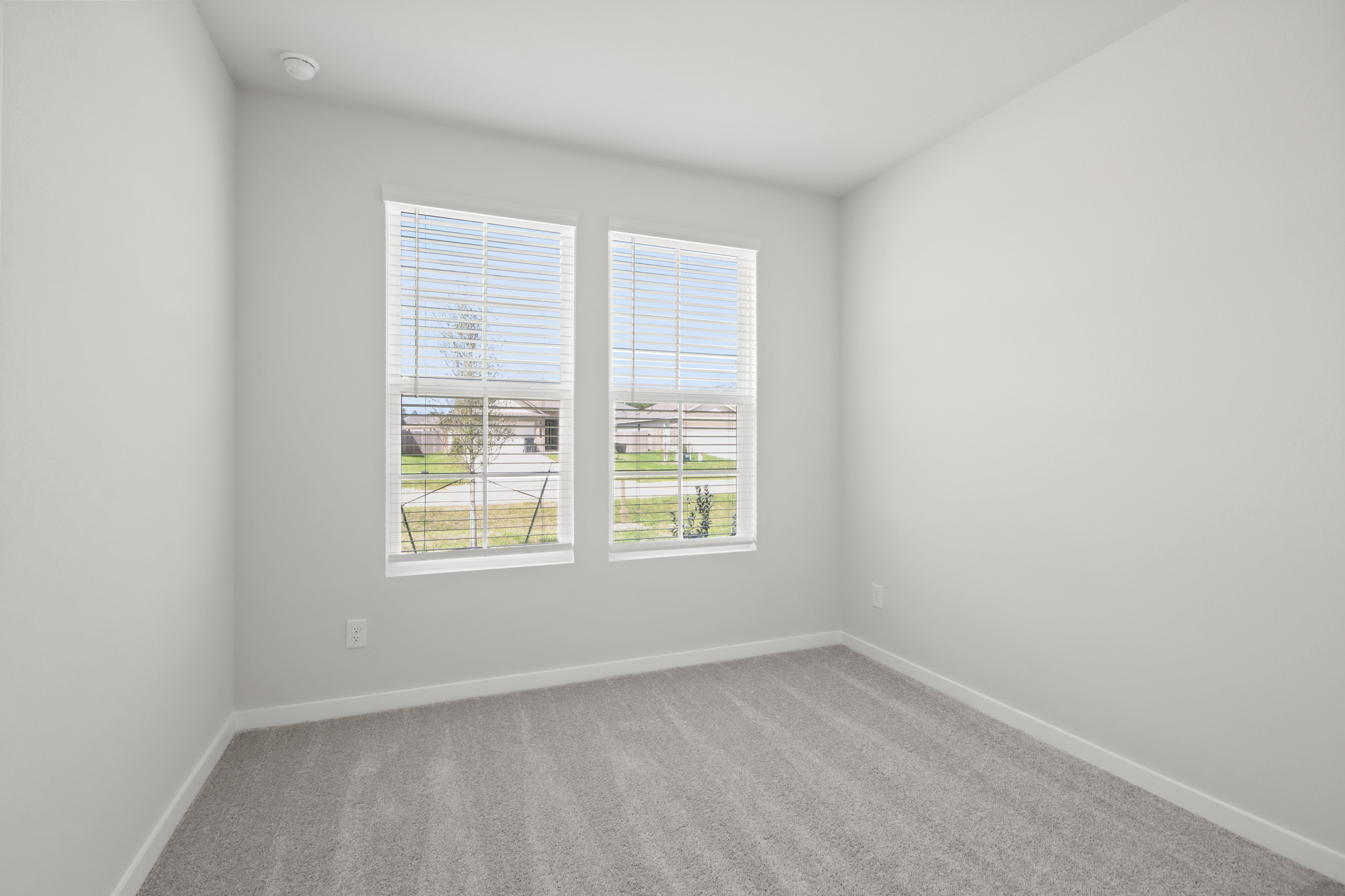 A room with a window and a carpet.