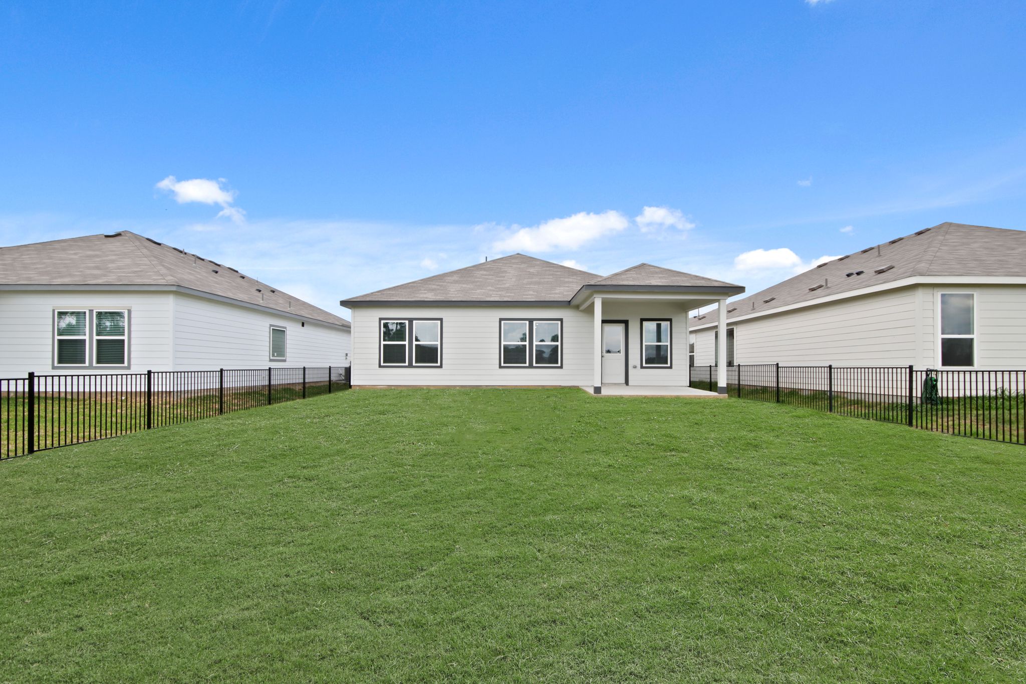 A large green lawn in front of a house.