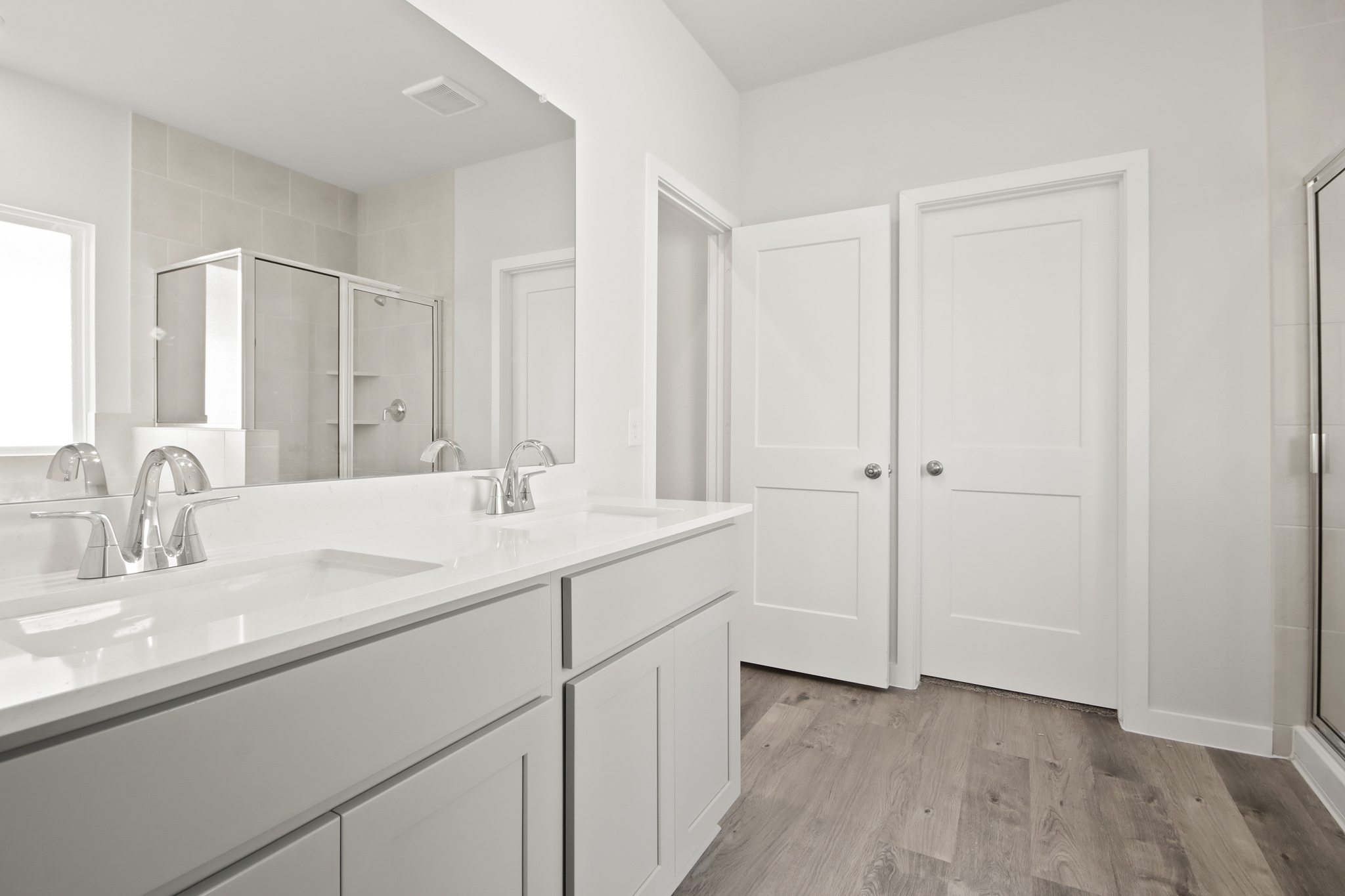 A bathroom with white cabinets.