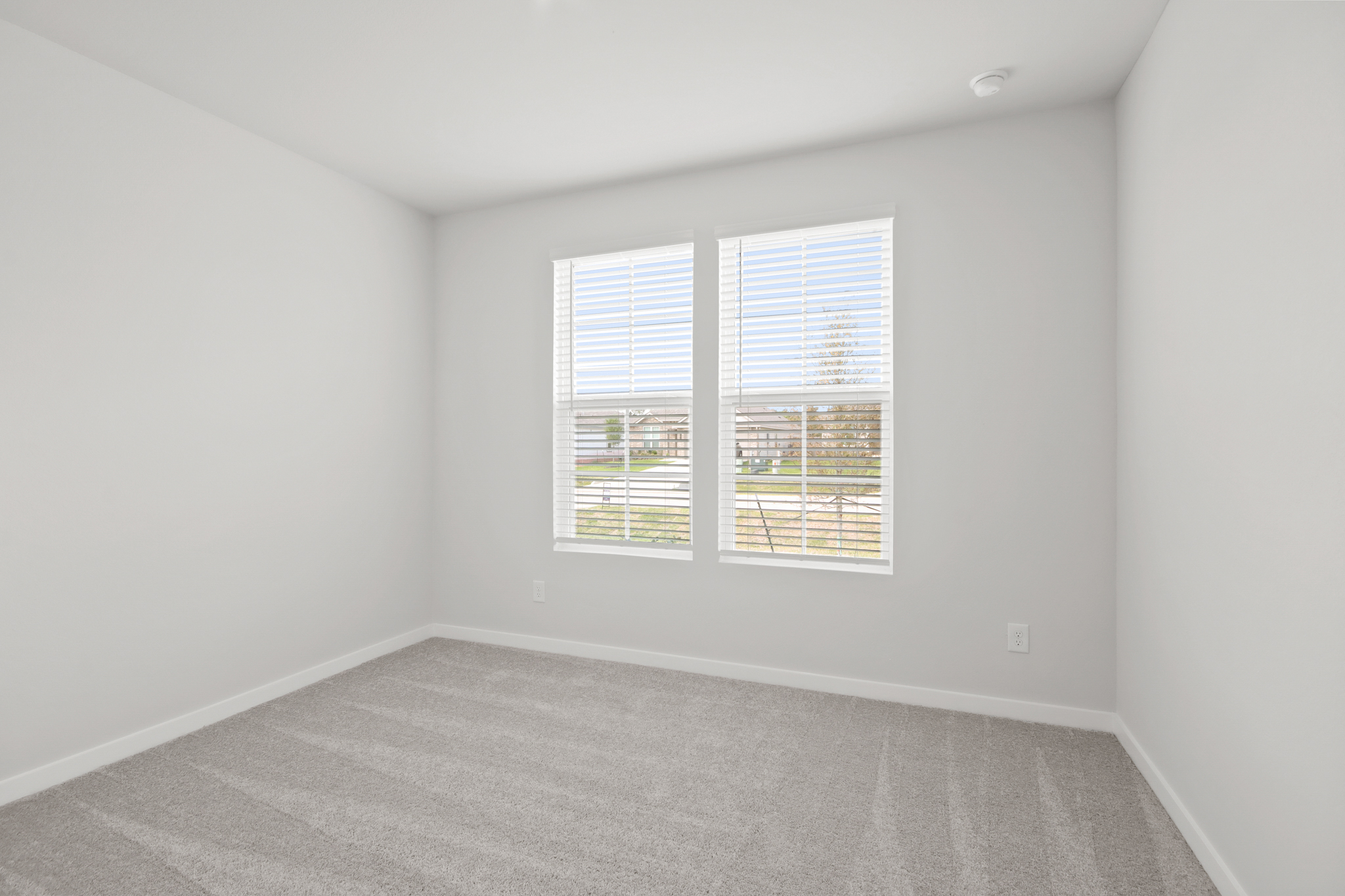 A room with a window and a carpet.