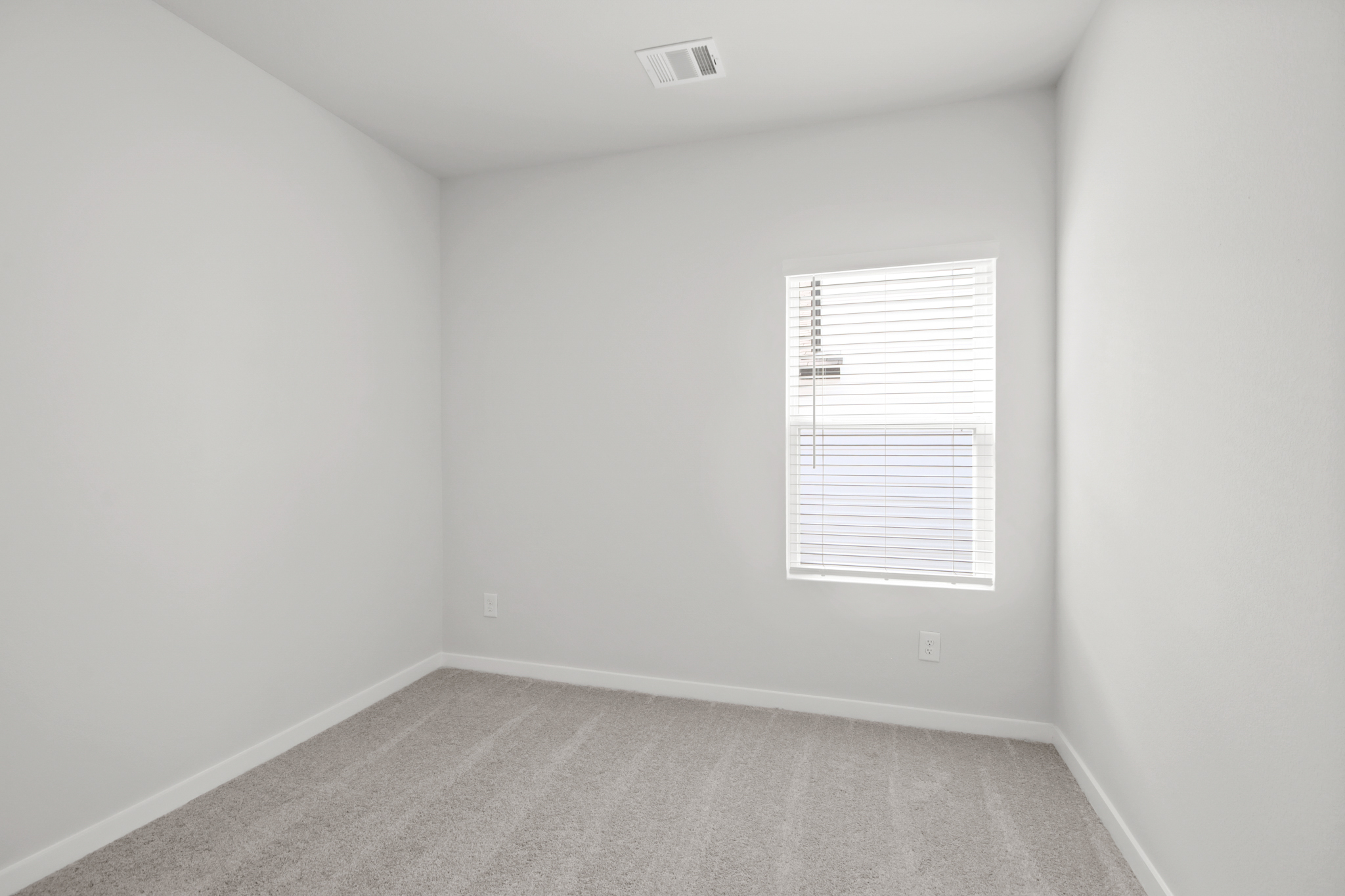 A room with a window and a carpet.