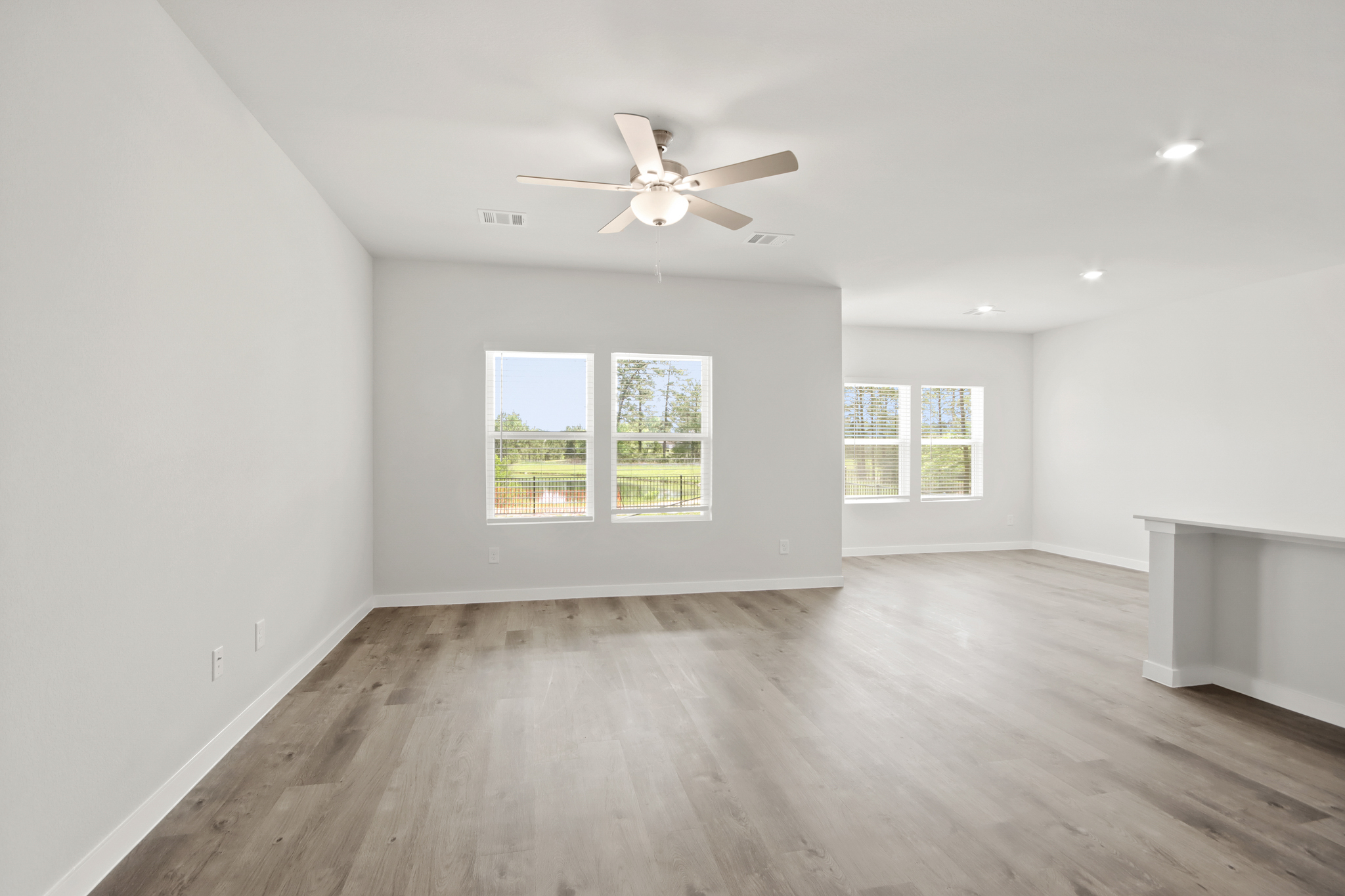 A room with a wood floor and a ceiling fan.