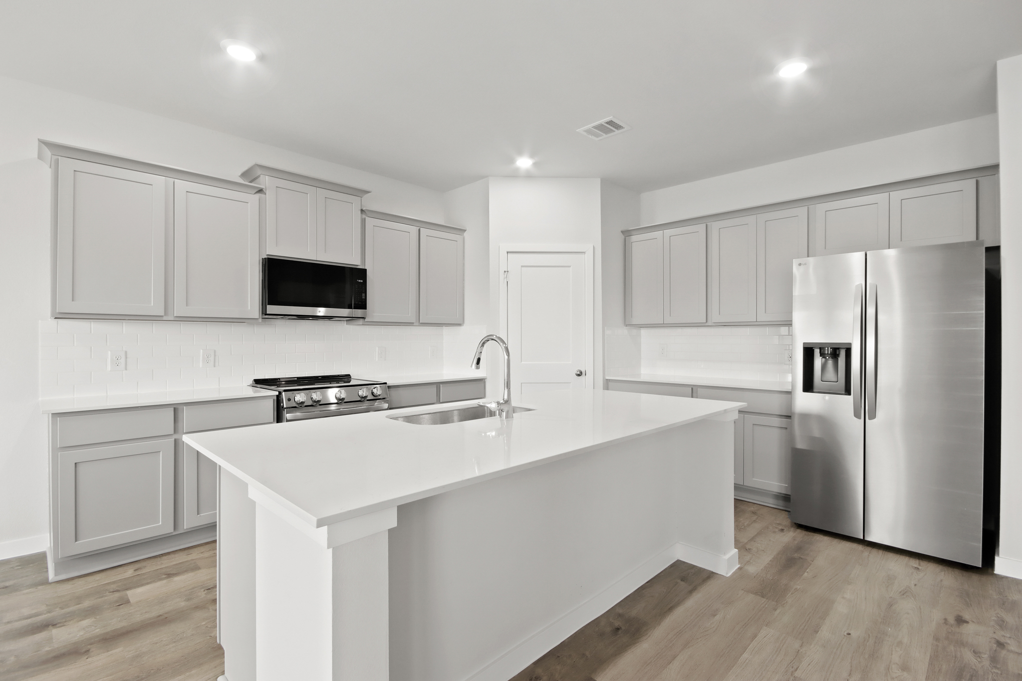 A kitchen with white cabinets.